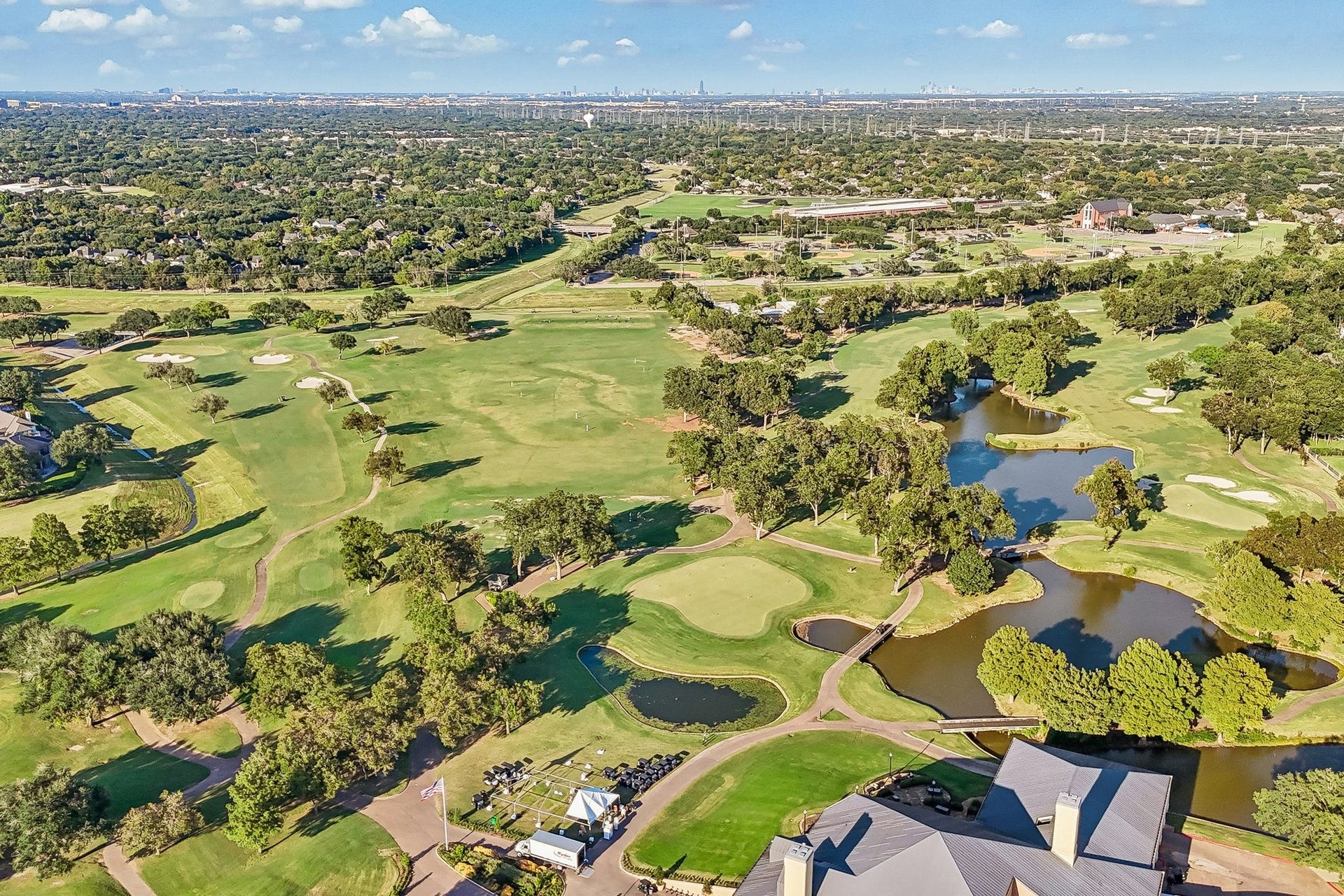 Sweeping aerial views of TPC Houstons golf course, featuring manicured fairways, strategically placed water features, and tree-lined greens