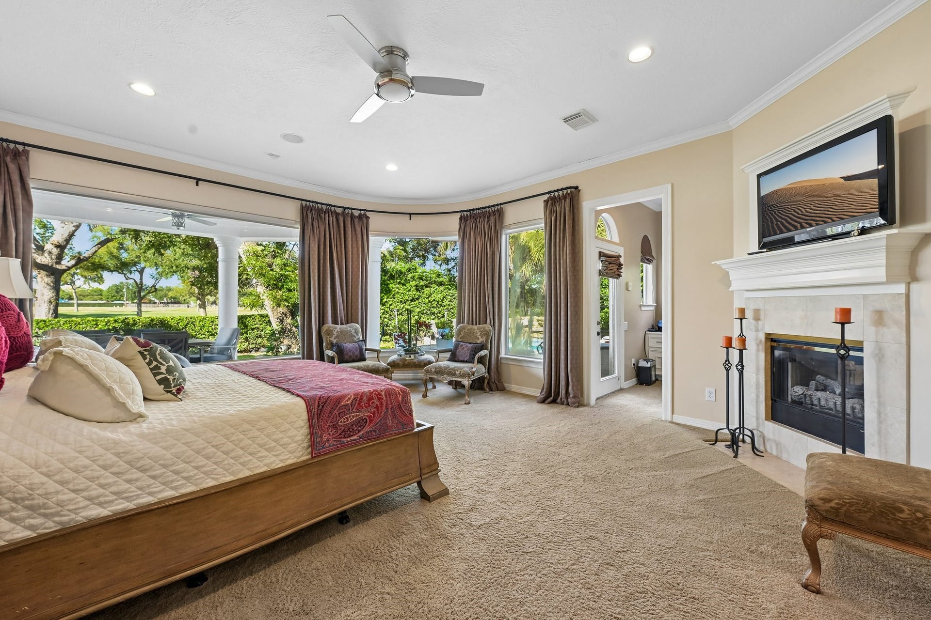 Spacious primary suite with a private fireplace and direct access to the covered patio, creating a seamless connection to the backyard retreat