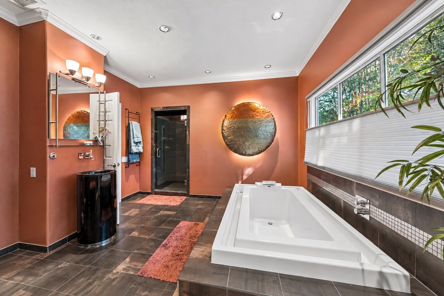 Secondary bathroom featuring a built-in soaking tub, separate walk-in shower, and distinctive warm-toned walls complemented by dark tile flooring