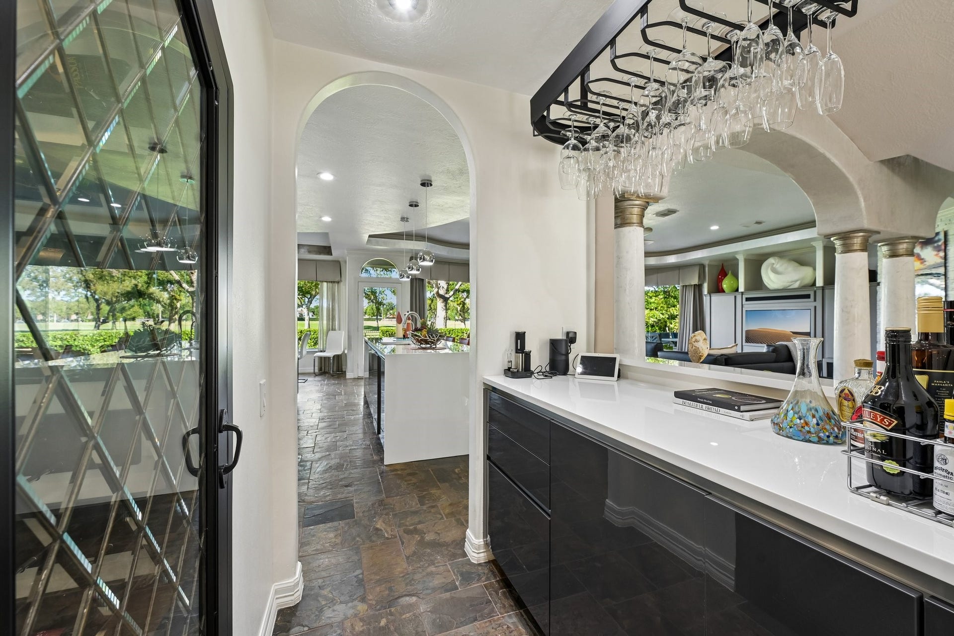 Stylish dry bar polished countertops, and elegant glassware storage, perfect for hosting guests