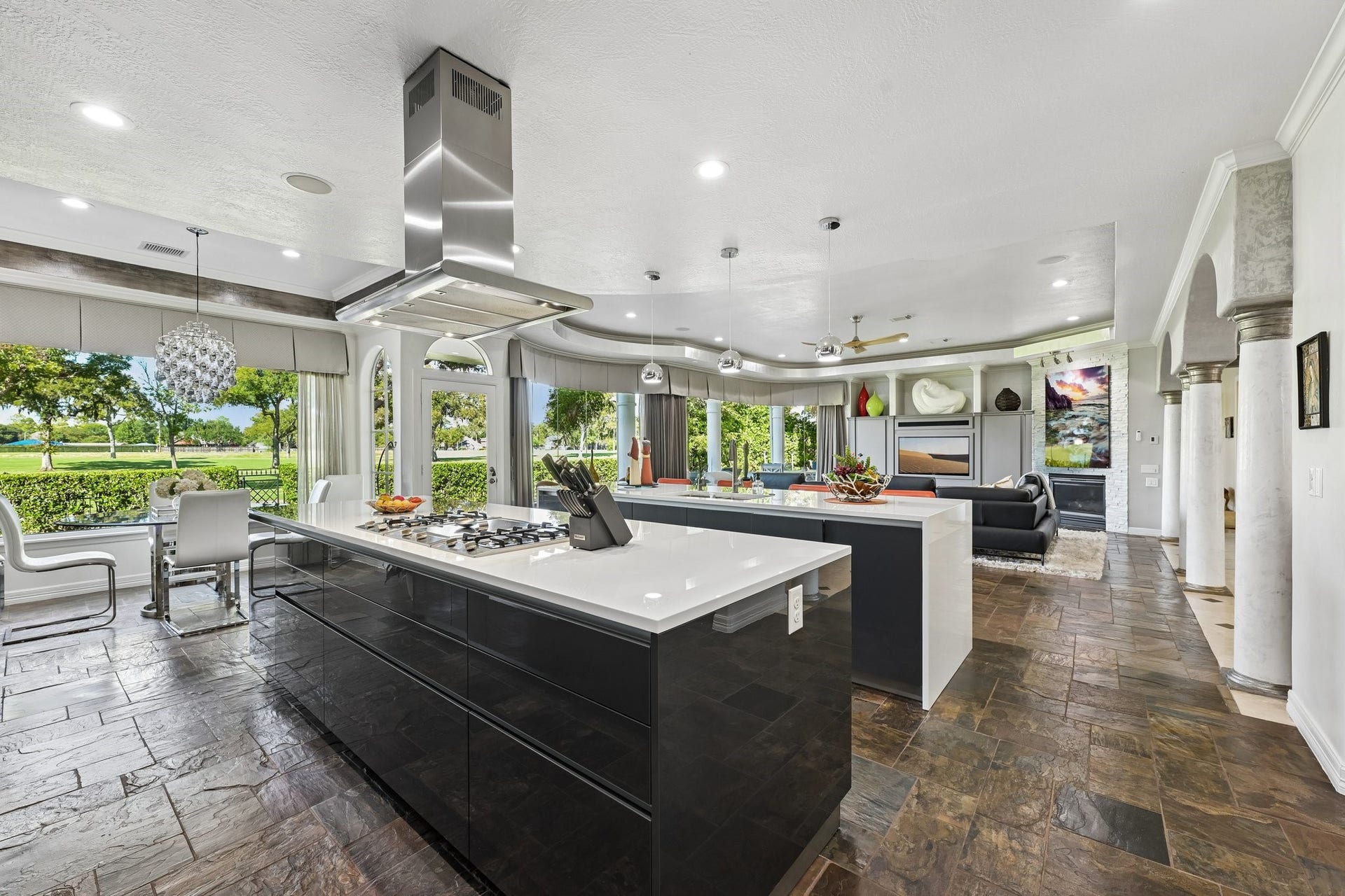 Walls of windows bring natural light into the kitchen and breakfast area, with scenic golf course views creating a beautiful backdrop for everyday dining