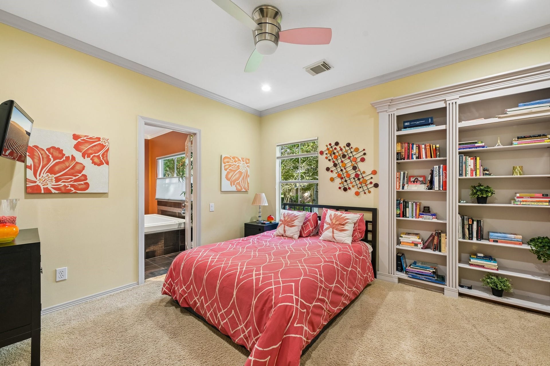 Secondary bedroom featuring custom built-in bookshelves with a concealed storage space, adding a unique architectural detail and practical functionality