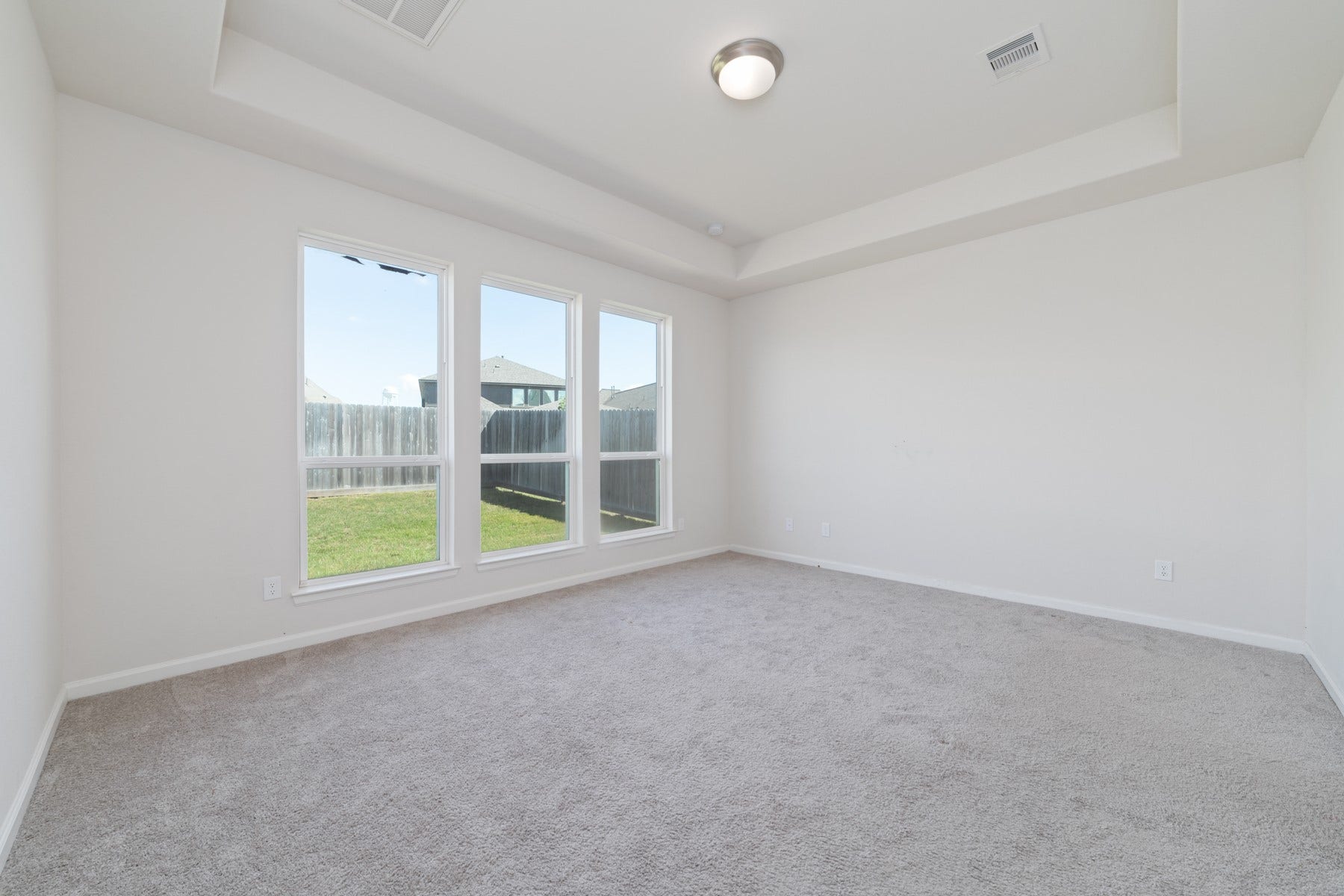 Discover the perfect retreat in this spacious primary bedroom, bathed in natural light from large windows and offering a tranquil view of the backyard.