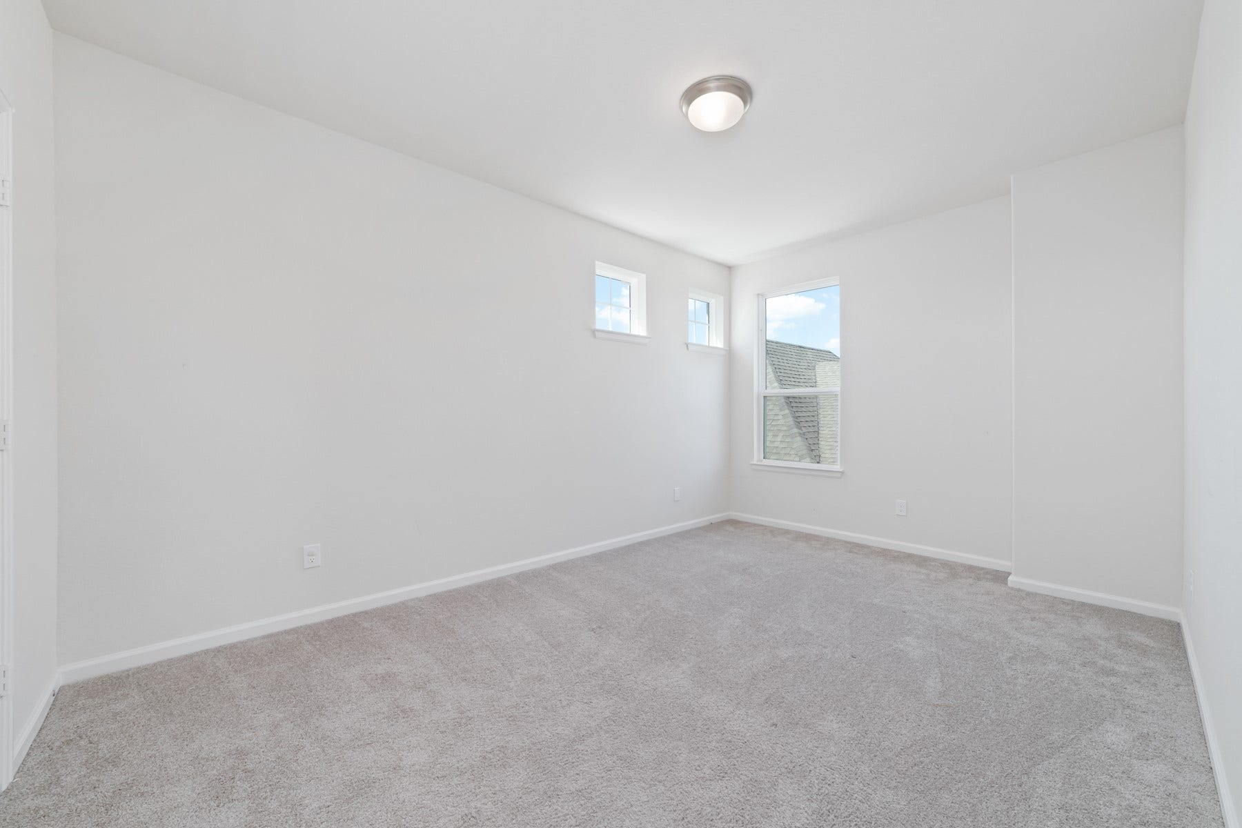 Bedroom #3 offers a bright and inviting space with plush carpeting and ample natural light, creating a cozy retreat.