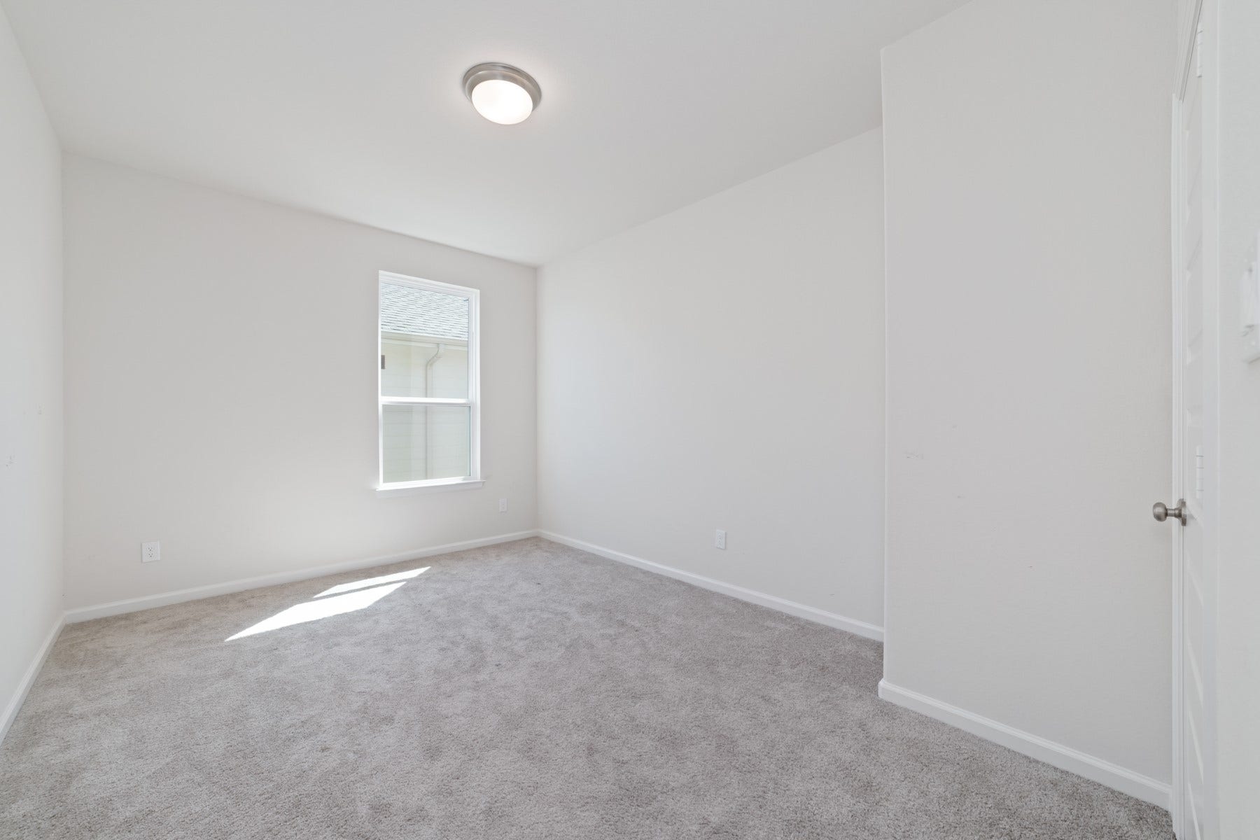 Bedroom #4 is a bright, inviting space with soft carpeting and ample natural light, perfect for relaxation or creating a personal retreat.