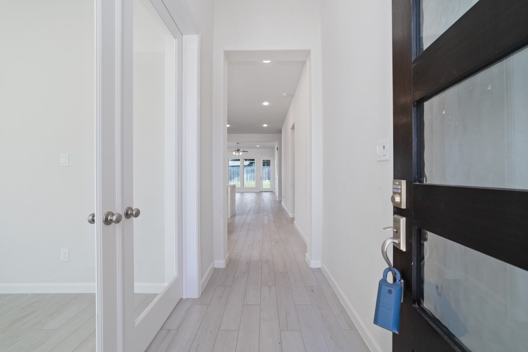 Step into a bright and inviting entryway that seamlessly guides you towards the heart of the home, offering a glimpse of the open, airy living spaces beyond.