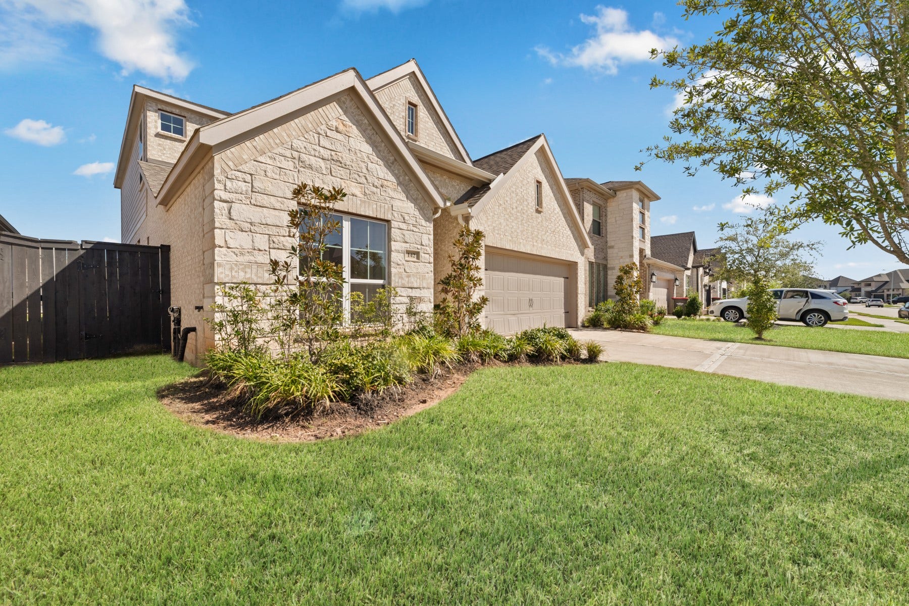 Charming two-story home with a stone facade in a peaceful neighborhood.