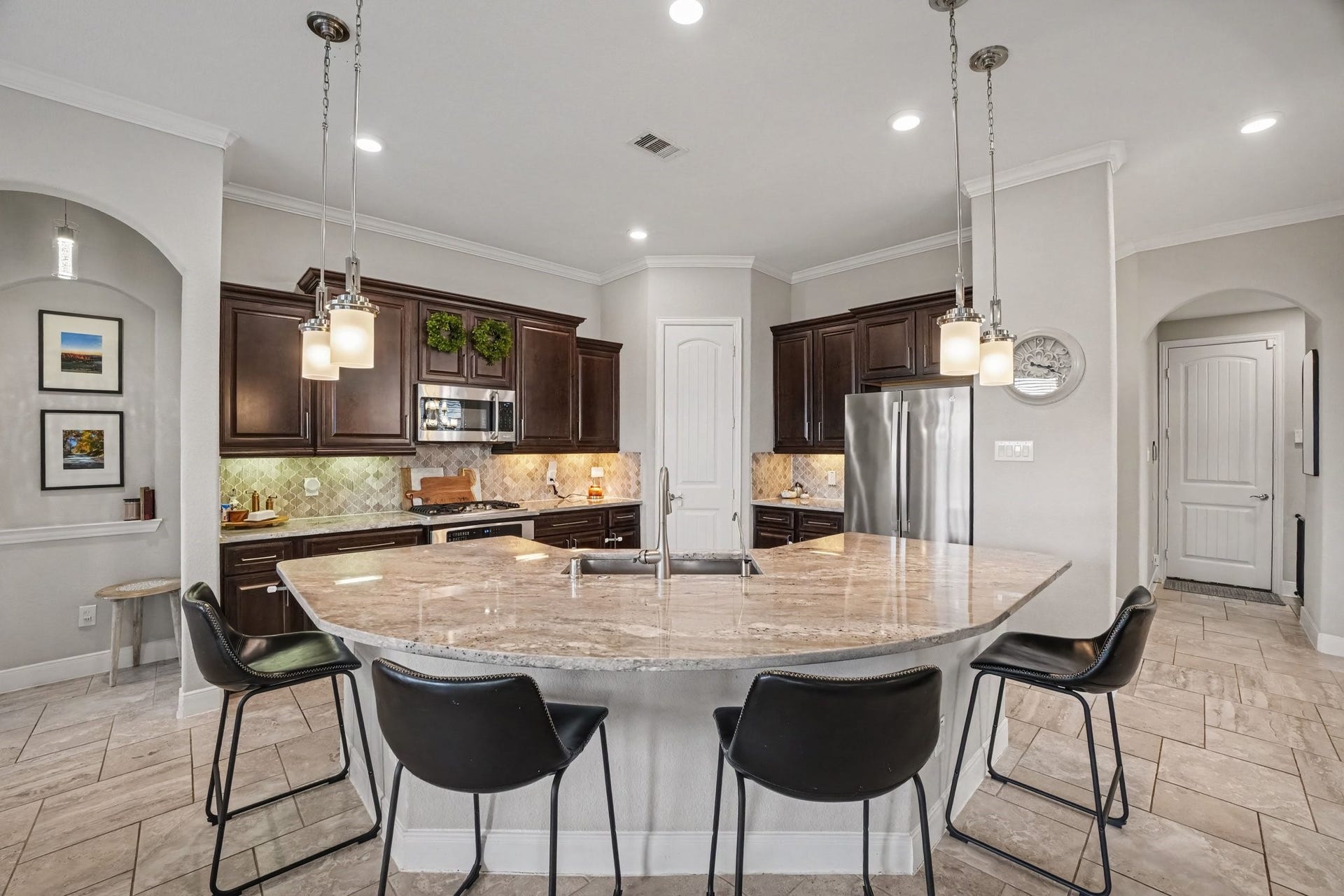 26438 Morgan Creek Lane, Katy, TX 77494 At the centerpiece is a expansive, curved granite island illuminated by stylish pendant lights, featuring an undermount sink, goose-neck faucet, and comfortable bar-height seating.
