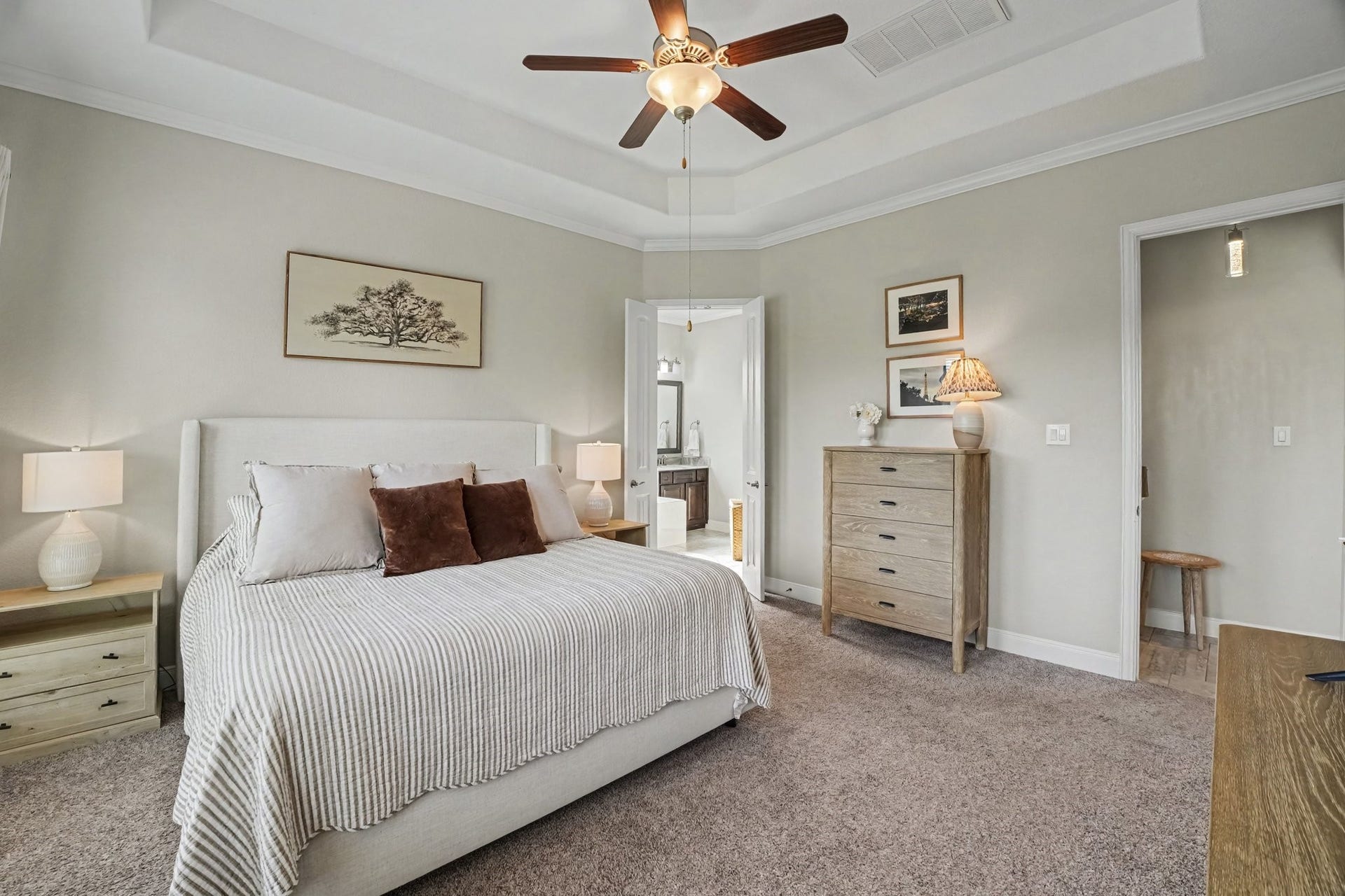 26438 Morgan Creek Lane, Katy, TX 77494 This luxurious primary suite serves as a serene sanctuary designed for ultimate comfort and relaxation. Elegant architectural features elevate the room, starting with an impressive recessed tray ceiling with double crown molding and a classic ceiling fan centered overhead.