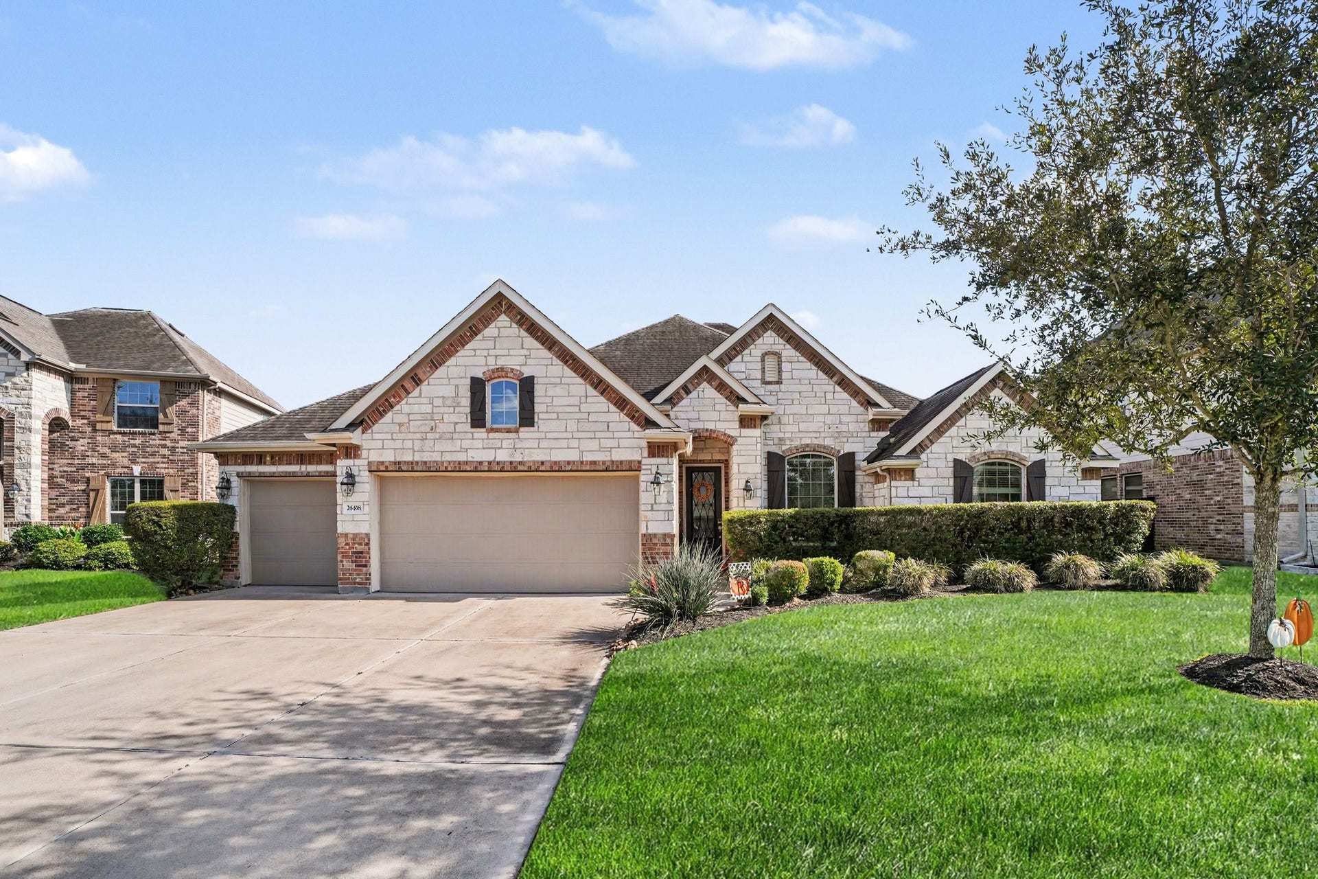 26438 Morgan Creek Lane, Katy, TX 77494 Arched windows, accent stonework, classic lantern exterior lighting, and textured shingle roofing give this home an elegant, craftsman-inspired aesthetic.