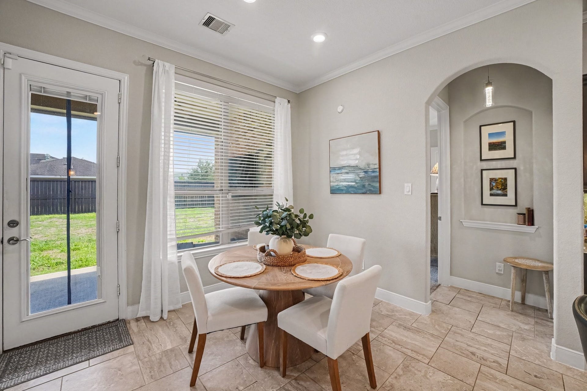 26438 Morgan Creek Lane, Katy, TX 77494 This charming breakfast nook offers a bright and comfortable space for casual daily dining. Positioned alongside a large window with blinds and sheer drapes, the area is bathed in natural light and provides serene views of the backyard. A glass-paneled exterior door gives immediate, convenient access to the outdoor patio space.