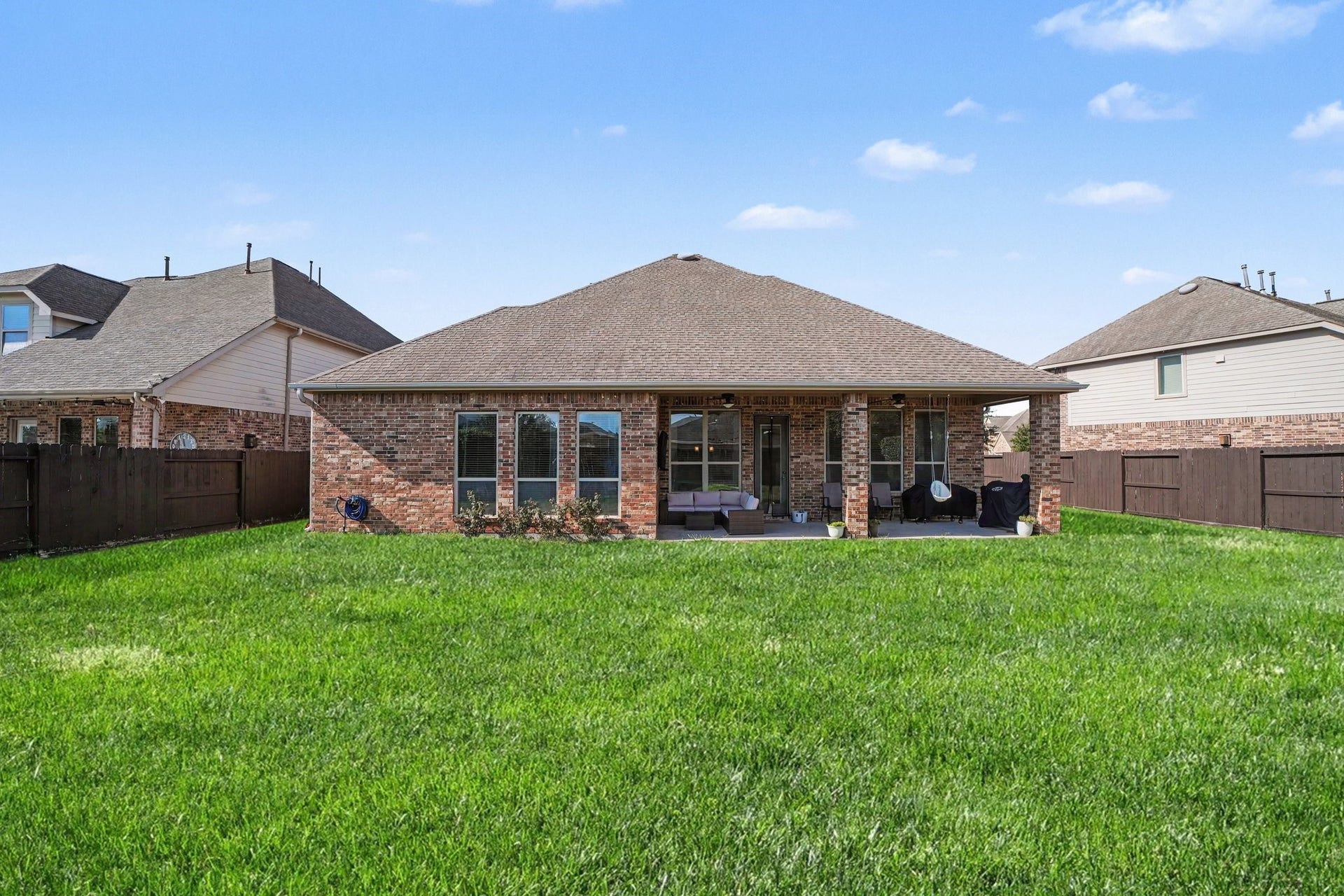 26438 Morgan Creek Lane, Katy, TX 77494 Step out into a vast outdoor haven featuring an expansive, fully fenced backyard with endless possibilities for relaxation, play, and outdoor entertaining. The rear exterior showcases timeless, classic brick masonry and a large covered patio supported by handsome brick columns.