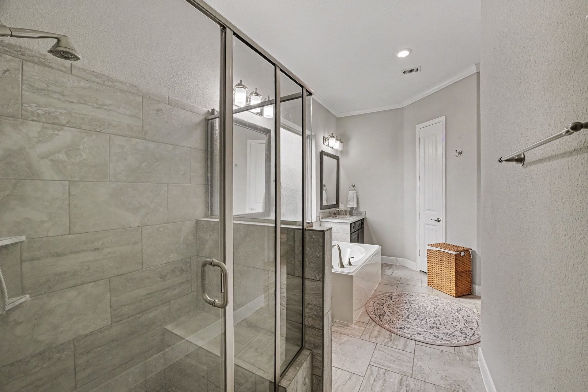 26438 Morgan Creek Lane, Katy, TX 77494 A glass-enclosed walk-in shower lined with elegant tile surrounds completes the suite, complemented by soft neutral walls, crisp white crown molding, and durable tile flooring throughout.