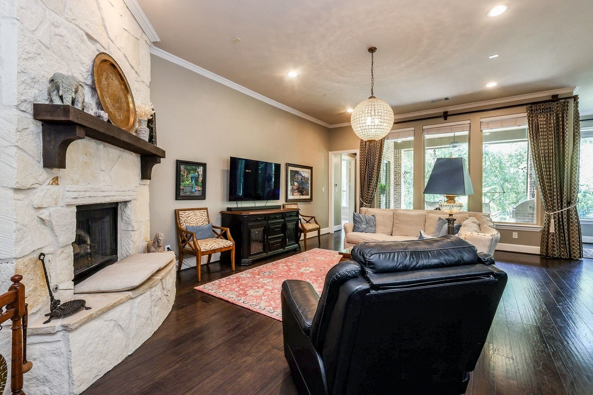 4715 Trickle Creek Court, Fulshear, TX 77441 Living room with upgraded chandelier and stone fireplace.