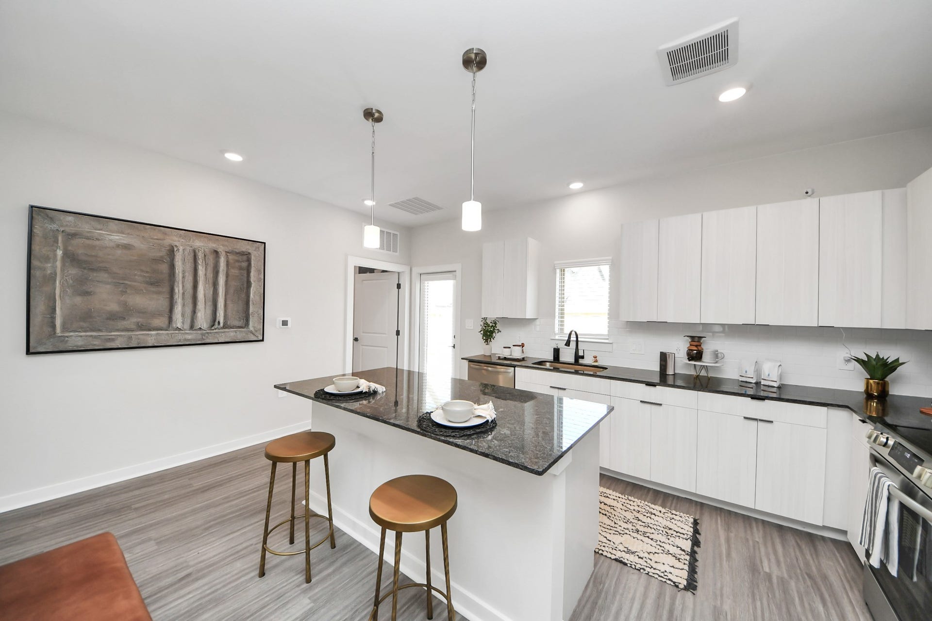Boasting luxury finishes-stylish Island kitchen,granite counters,subway tile backsplash,ample custom cabinet space,stainless appliances,refrigerator,full size washer&dryer included,wood-like flooring throughout,open concept floor plan.