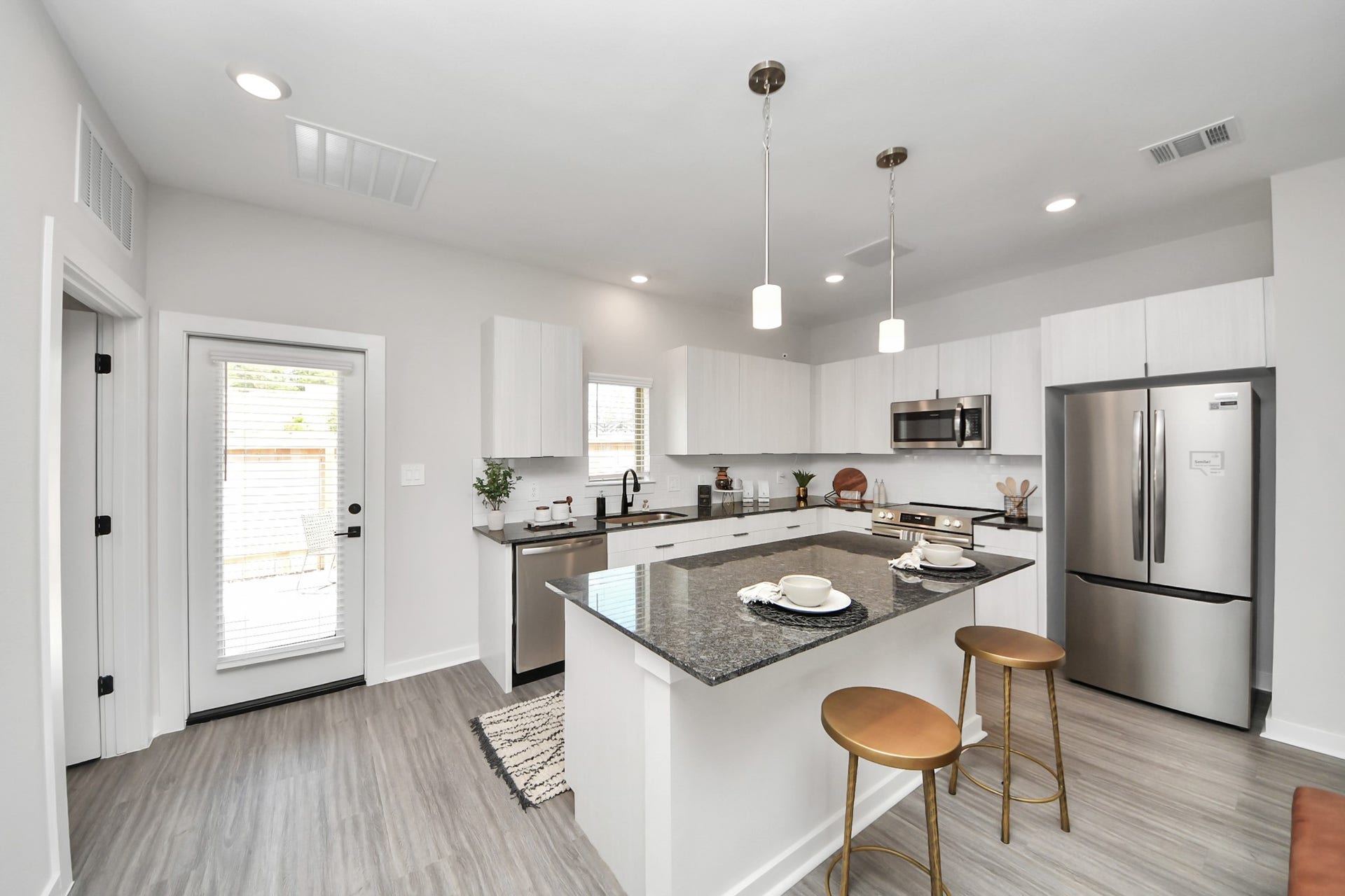Boasting luxury finishes-stylish Island kitchen,granite counters,subway tile backsplash,ample custom cabinet space,stainless appliances,refrigerator,full size washer&dryer included,wood-like flooring throughout,open concept floor plan.