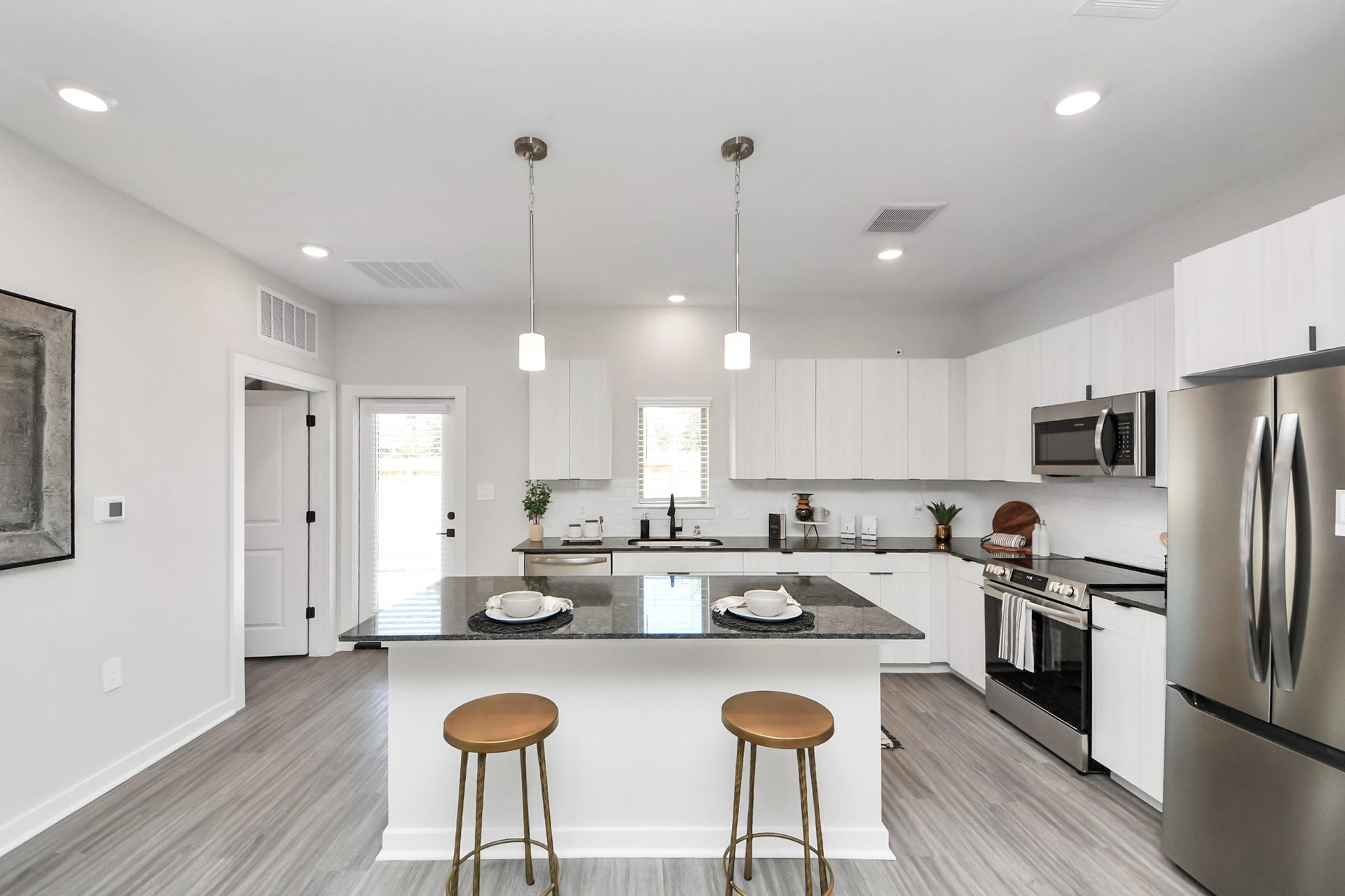 Boasting luxury finishes-stylish Island kitchen,granite counters,subway tile backsplash,ample custom cabinet space,stainless appliances,refrigerator,full size washer&dryer included,wood-like flooring throughout,open concept floor plan.
