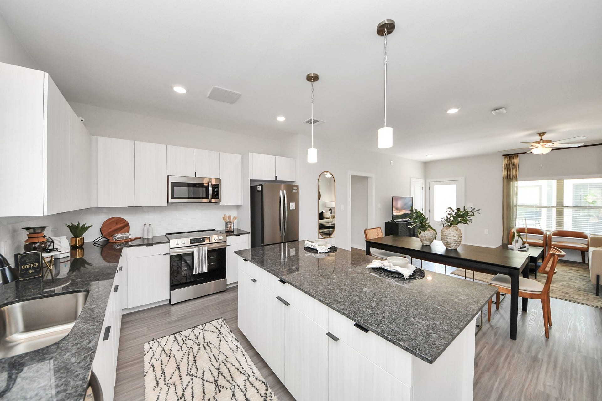 Boasting luxury finishes-stylish Island kitchen,granite counters,subway tile backsplash,ample custom cabinet space,stainless appliances,refrigerator,full size washer&dryer included,wood-like flooring throughout,open concept floor plan.
