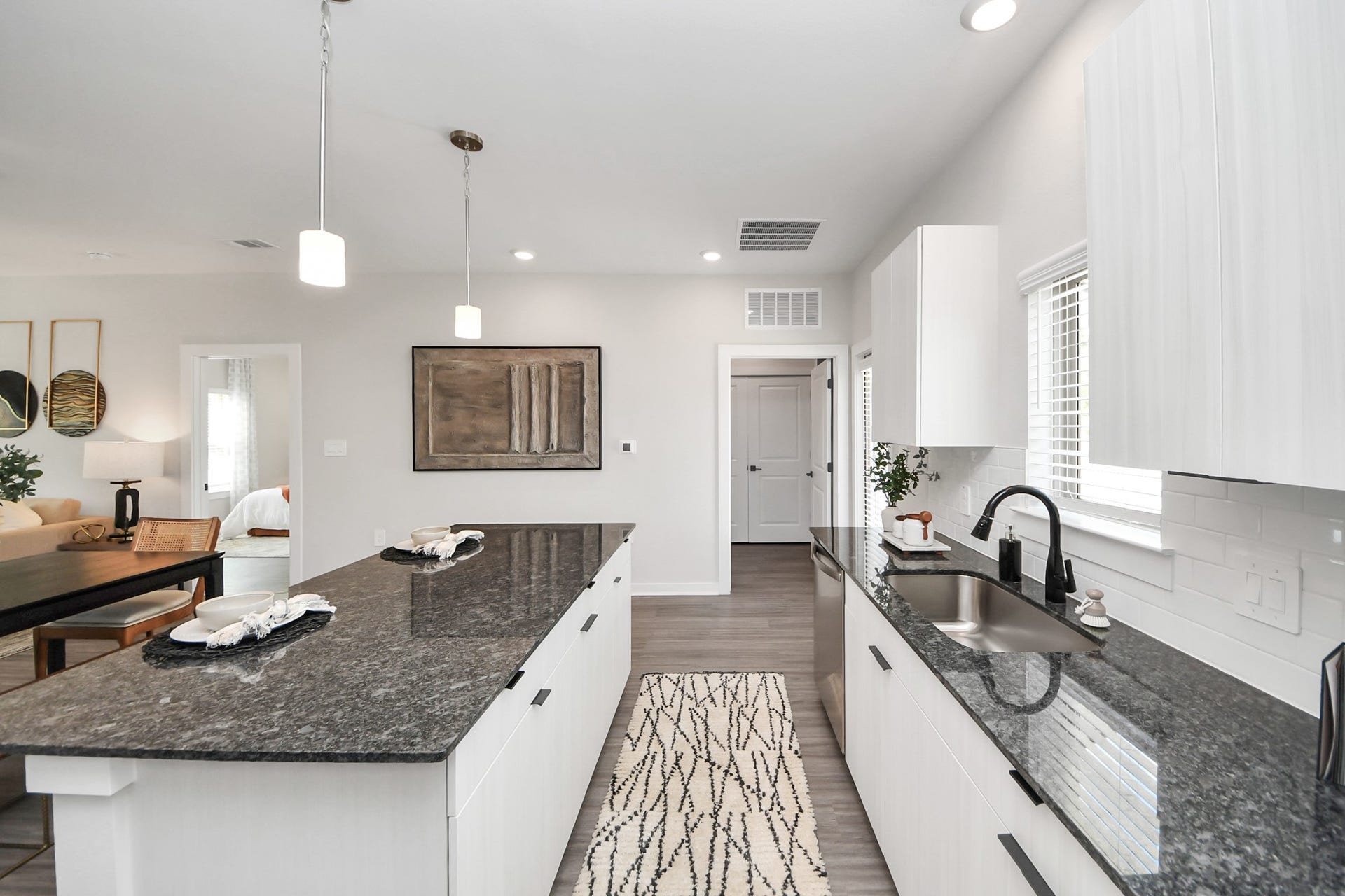 Boasting luxury finishes-stylish Island kitchen,granite counters,subway tile backsplash,ample custom cabinet space,stainless appliances,refrigerator,full size washer&dryer included,wood-like flooring throughout,open concept floor plan.