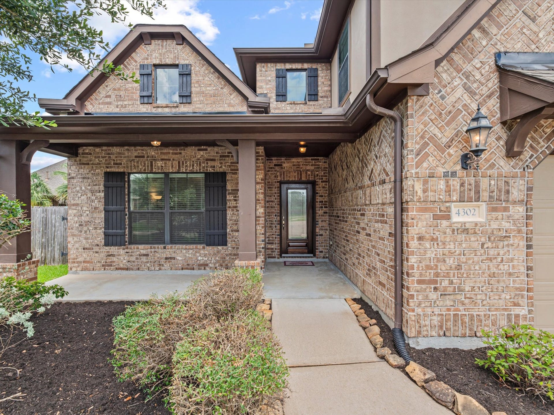 4302 Kent Ranch Court, Katy, TX 77494 The charming brick exterior offers timeless curb appeal and welcomes you with a cozy covered front porchan inviting space to enjoy your morning coffee or greet guests.