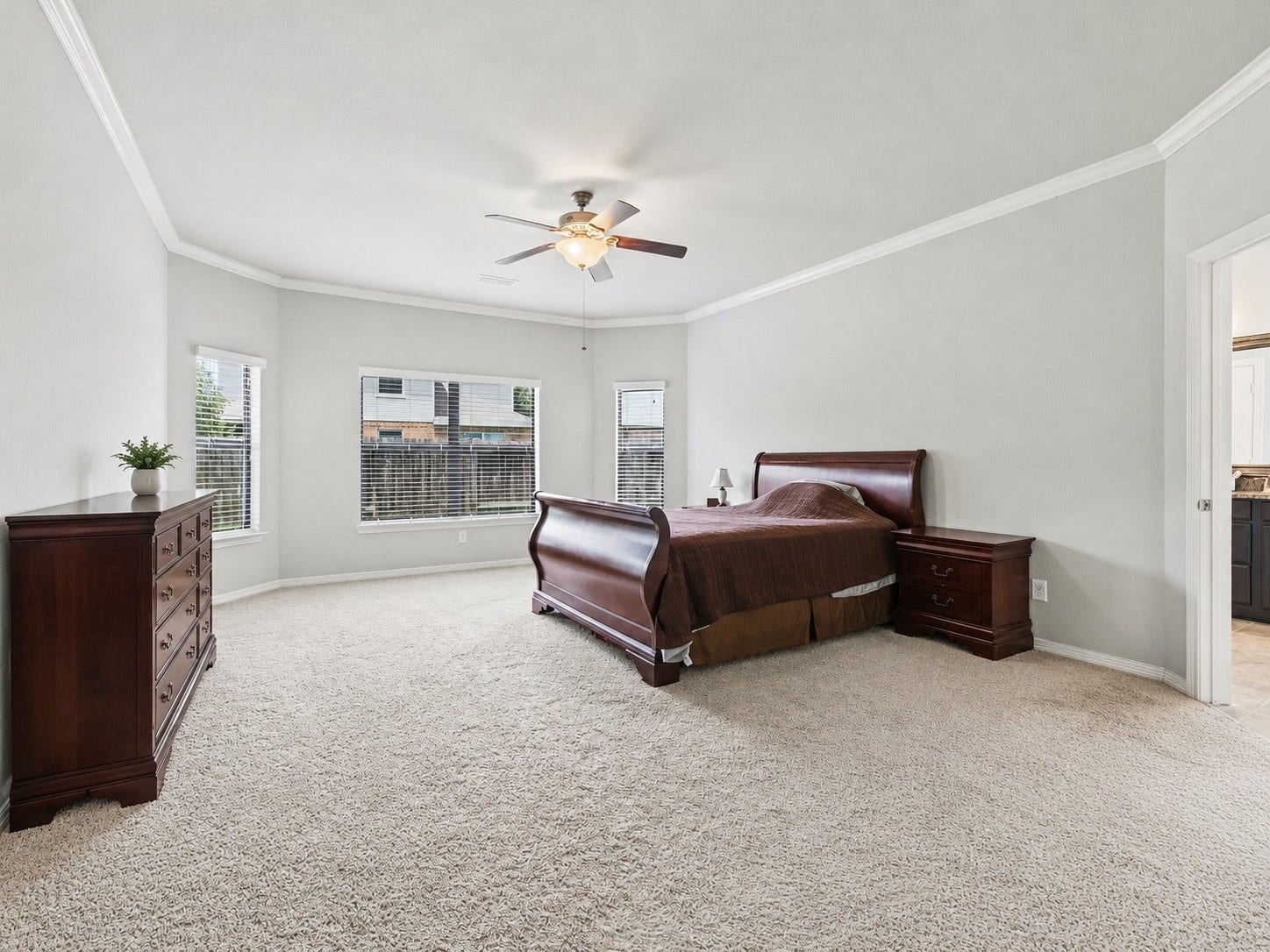 4302 Kent Ranch Court, Katy, TX 77494 The spacious primary suite offers a peaceful retreat, featuring plush carpeting, oversized windows that fill the room with natural light, and plenty of space for comfortable furnishings. Primary bedroom measures 15' x 21'7". Some furniture added virtually.