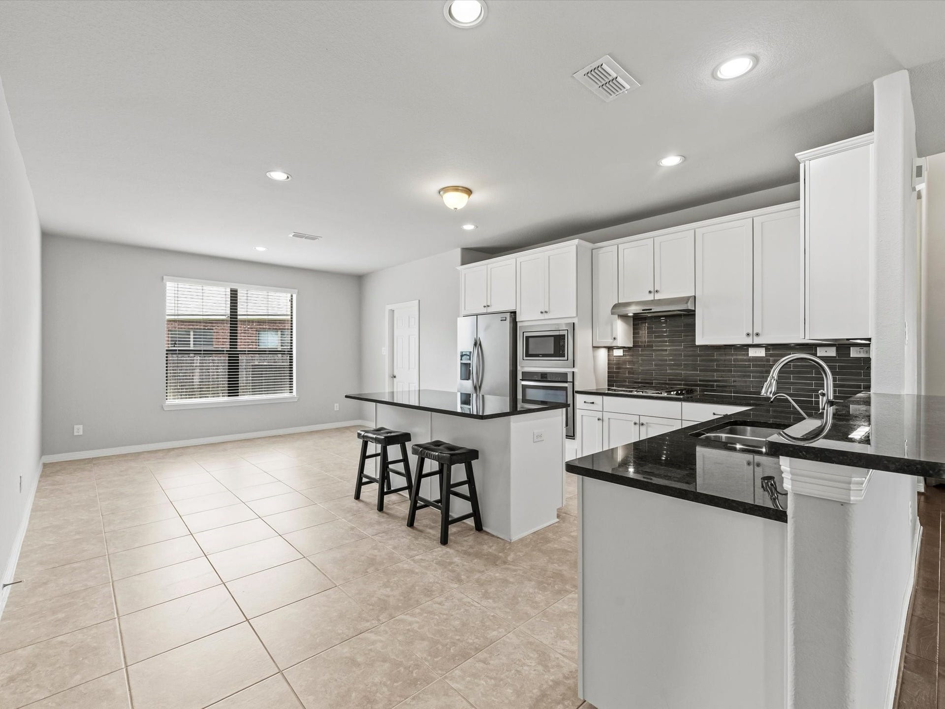 4302 Kent Ranch Court, Katy, TX 77494 Another view of the kitchen highlights its seamless connection to the bright breakfast area, creating the perfect space to enjoy casual meals or morning coffee.