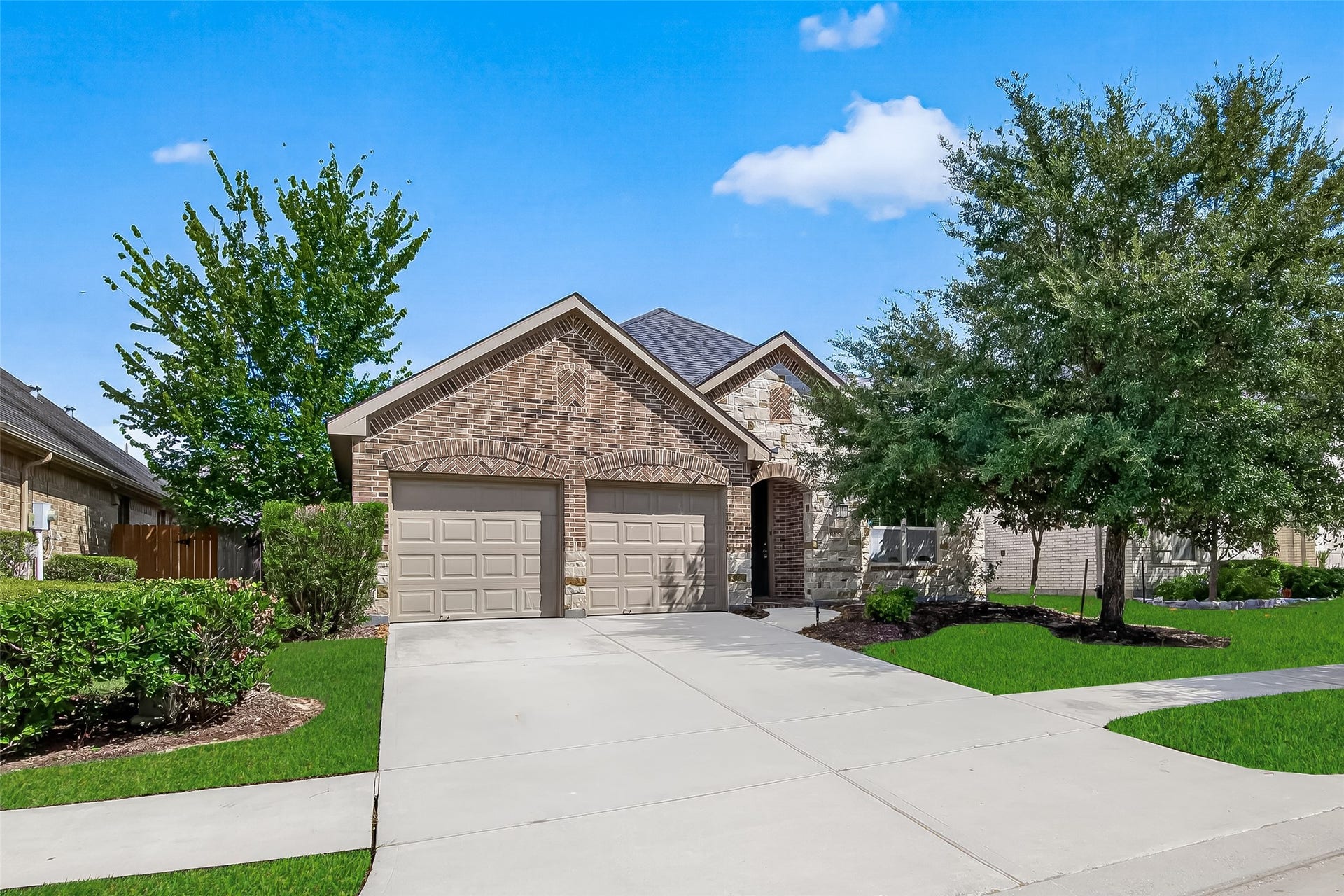 8155 Laughing Falcon Trail, Conroe, TX 77385 Welcoming exterior view featuring attractive brickwork, a well-maintained front yard, and inviting curb appeal.