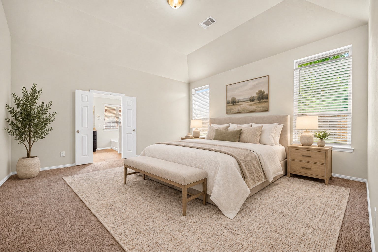 8155 Laughing Falcon Trail, Conroe, TX 77385 Expansive primary bedroom featuring a vaulted ceiling, neutral carpeting, tall windows, and an en-suite bathroom. Virtually Staged.
