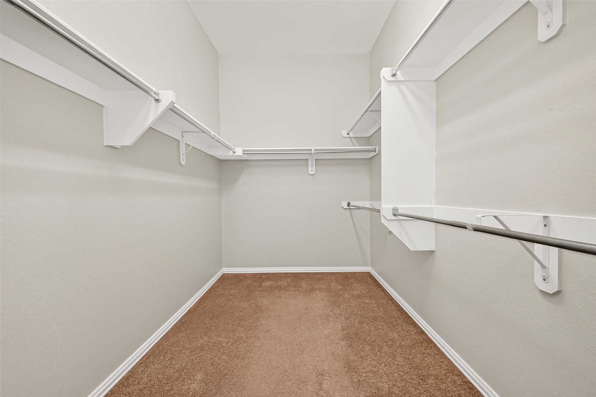 8155 Laughing Falcon Trail, Conroe, TX 77385 Generously sized primary walk-in closet with extensive shelving and hanging storage along multiple walls.