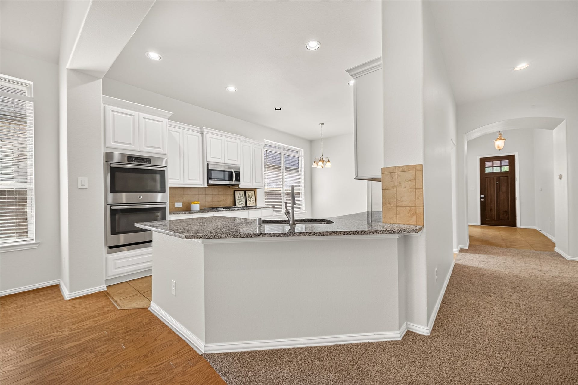 8155 Laughing Falcon Trail, Conroe, TX 77385 Open-concept view of the kitchen and living room featuring granite countertops, a breakfast bar, and easy access to the main living spaces.