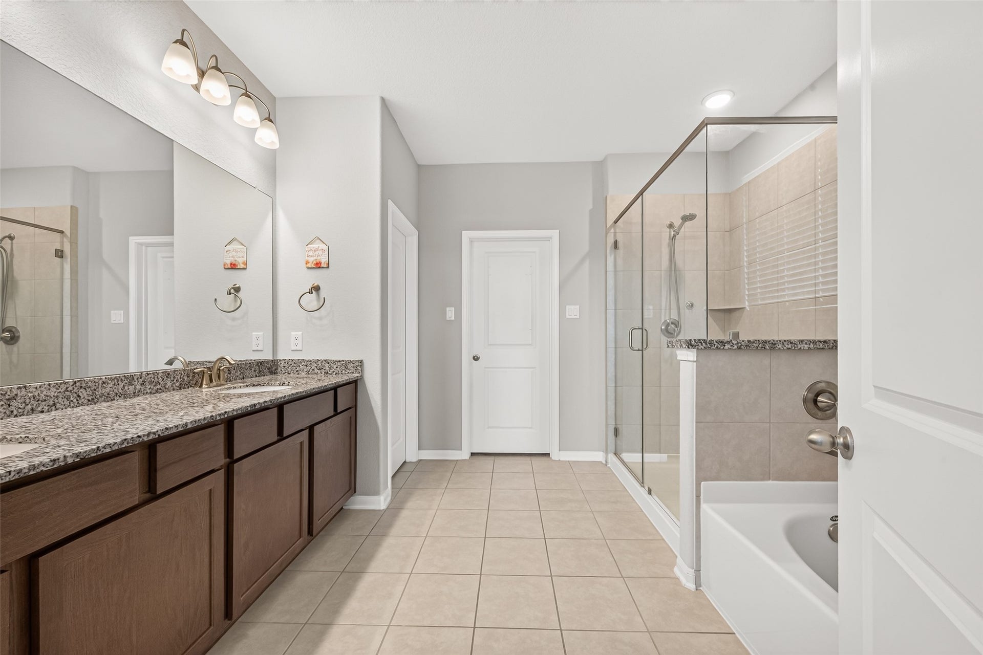 10707 Amador Peak Drive, Rosharon, TX 77583 Primary bathroom, double sinks, large mirror, bathroom window adds considerable natural lighting.