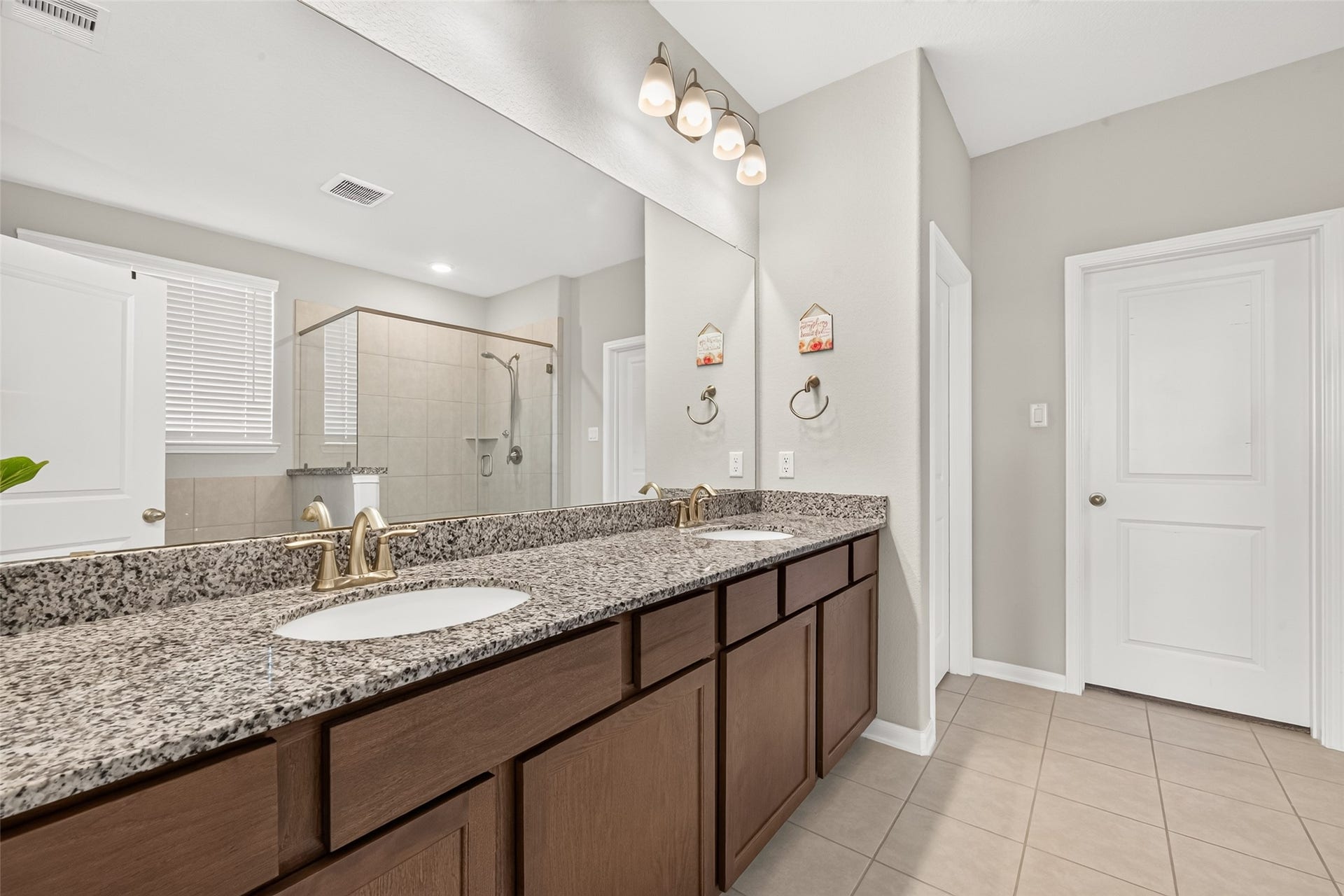 10707 Amador Peak Drive, Rosharon, TX 77583 Double sinks and a large mirror, plenty of cabinetry & storage space, great lighting in this bathroom. Water closer door and walk-in closet door straight ahead.