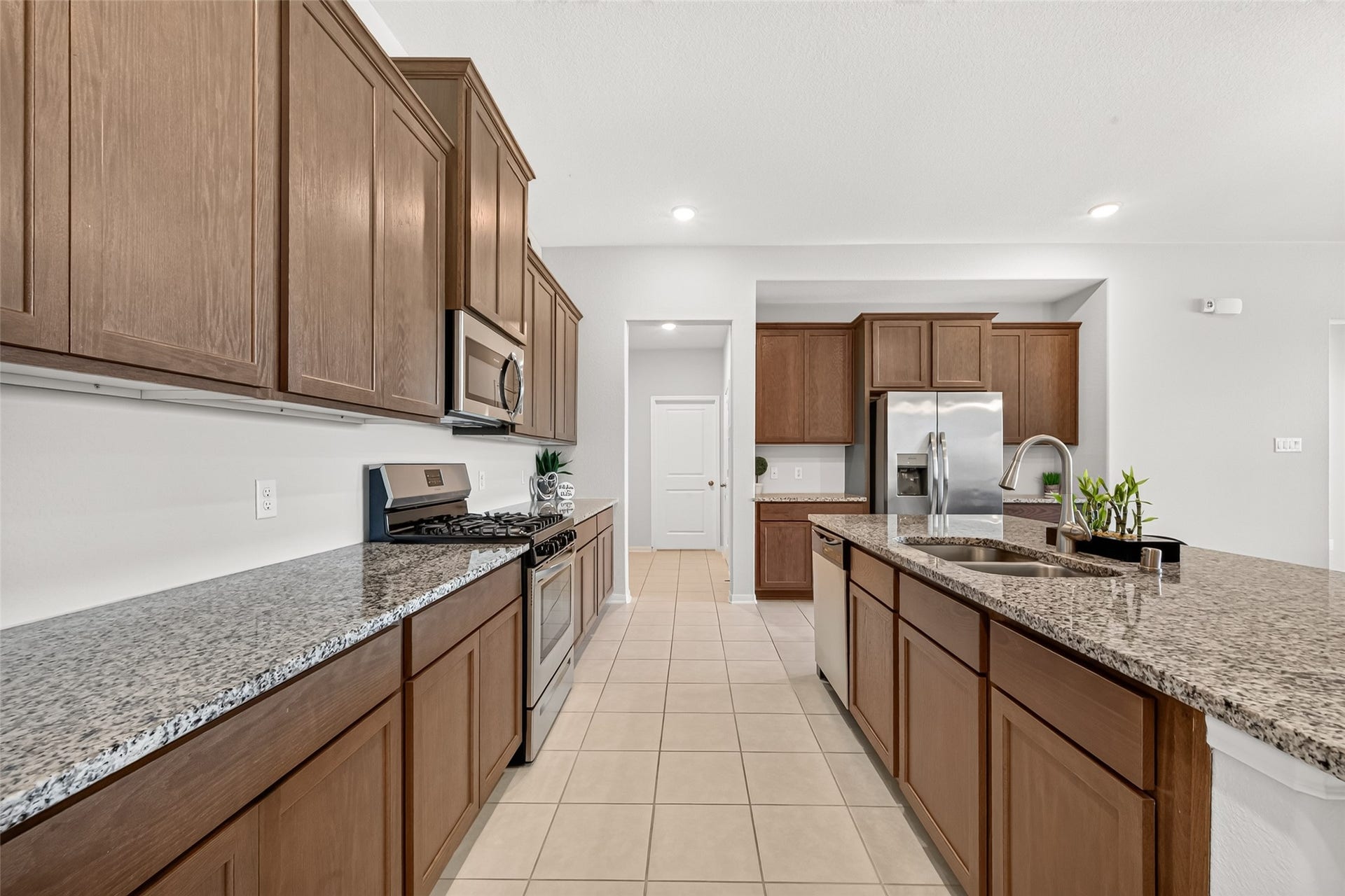 10707 Amador Peak Drive, Rosharon, TX 77583 Statement kitchen, granite countertops, gas range, built in microwave overhead. Past the kitchen, utility room, walk-in pantry & garage access.