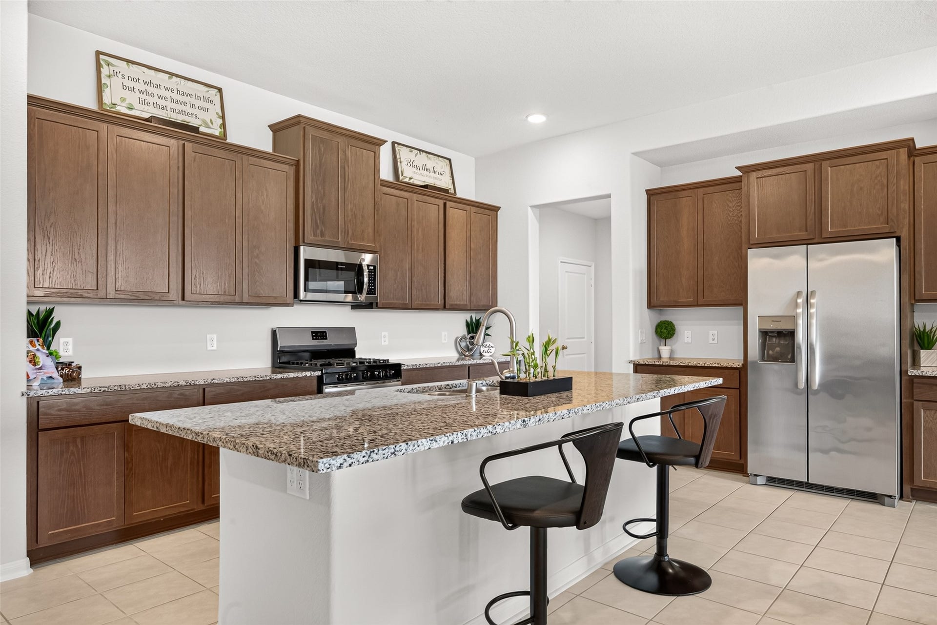 10707 Amador Peak Drive, Rosharon, TX 77583 Beautiful kitchen space with ample cabinetry, breakfast bar and tile flooring. Fridge included.