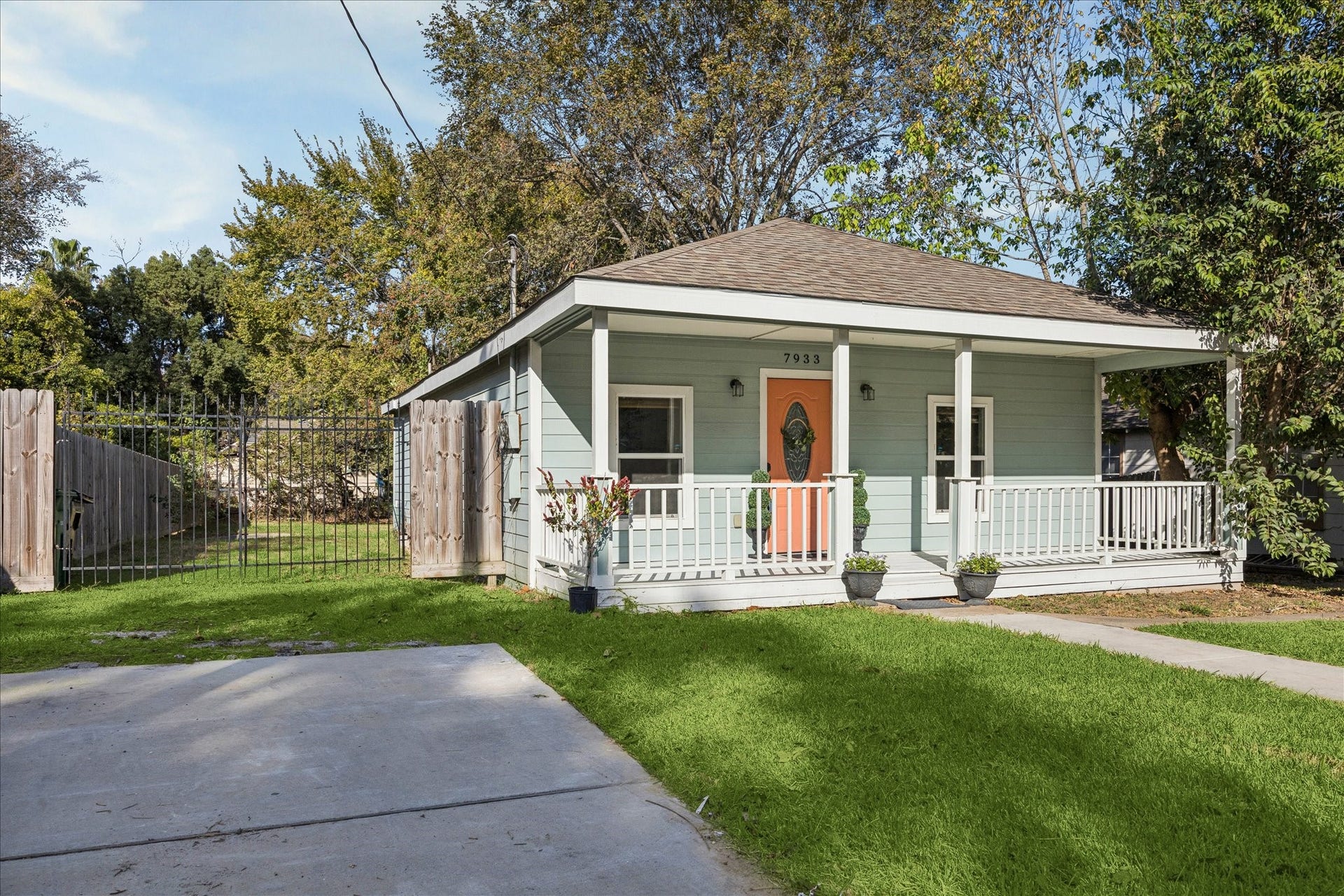 7933 Elwood Street, Houston, TX 77012 The property features a spacious fenced yard and ample driveway space, surrounded by mature trees for added privacy.