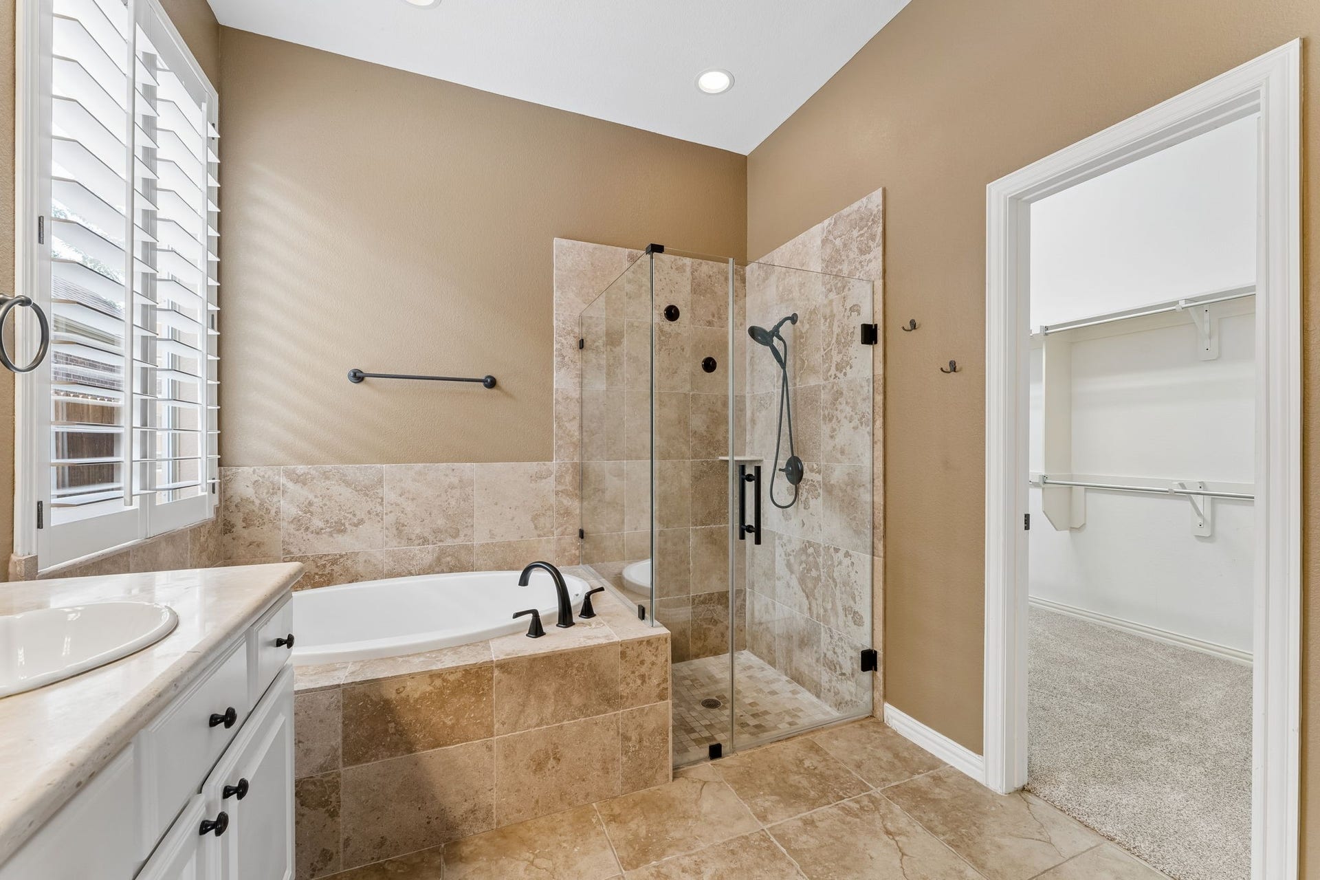 8210 Thunder Ridge Way, Missouri City, TX 77459 The primary bathroom boasts elegant tile work, a sleek glass shower enclosure, updated plumbing fixtures, and fresh paint for a modern touch.