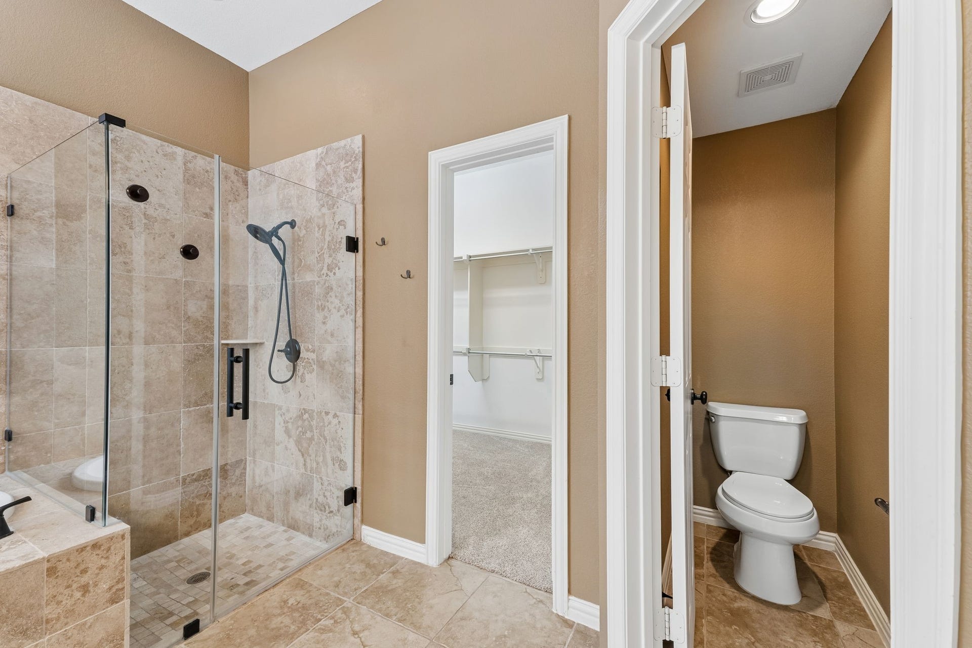 8210 Thunder Ridge Way, Missouri City, TX 77459 Sleek glass shower enclosure with adjacent access to a spacious walk-in closet.