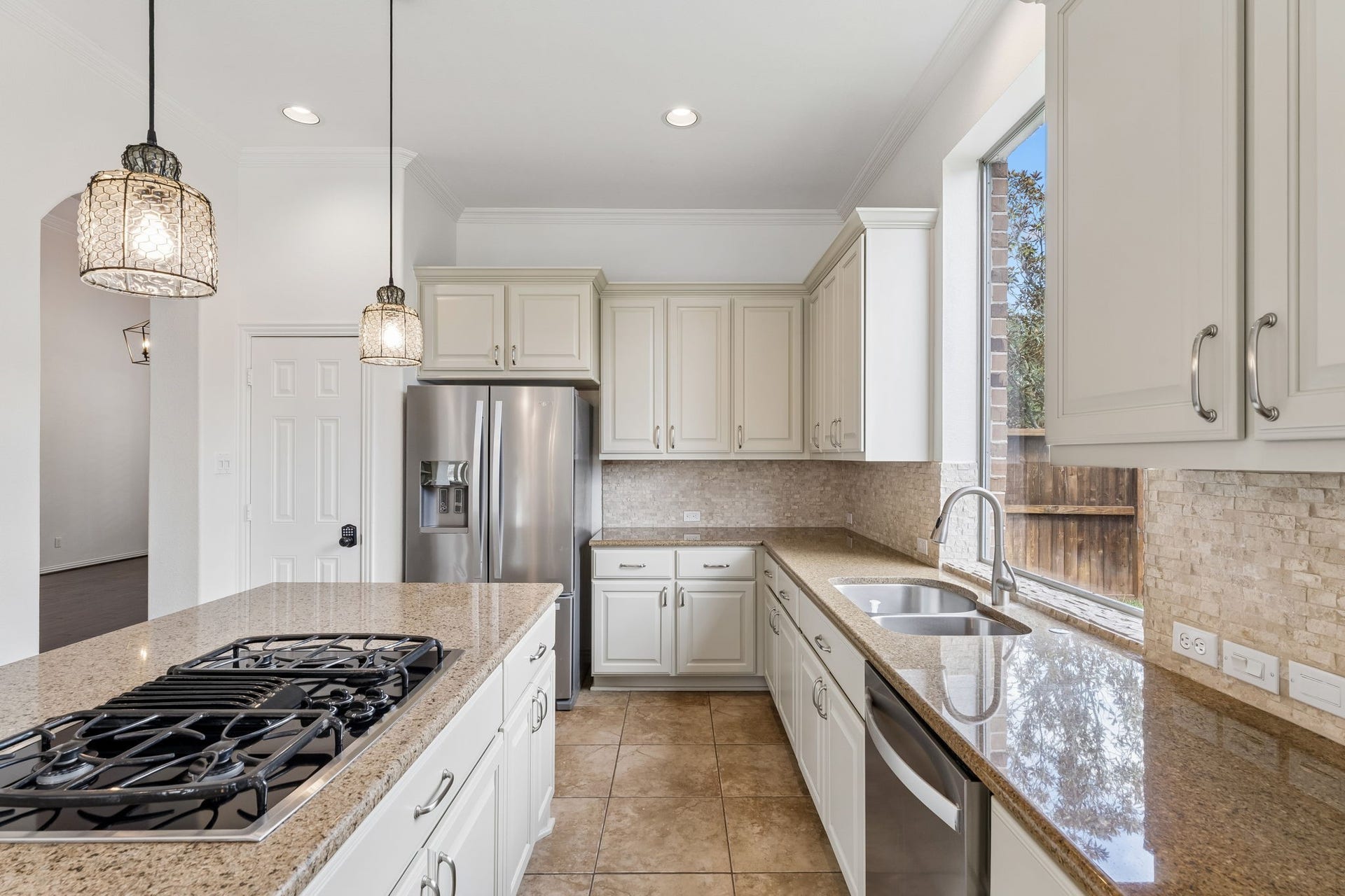 8210 Thunder Ridge Way, Missouri City, TX 77459 Elegant granite countertops, a honed marble backsplash, and new cabinets create a bright and inviting kitchen space.