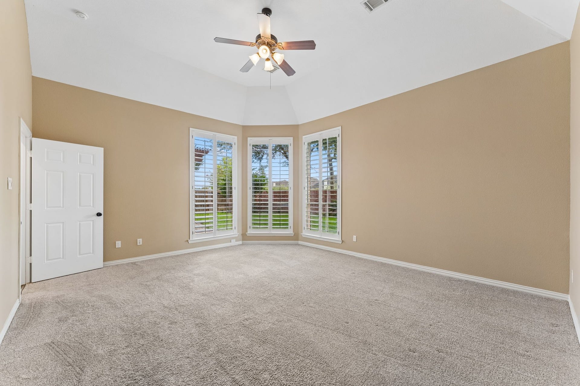 8210 Thunder Ridge Way, Missouri City, TX 77459 Spacious downstairs primary bedroom with elegant coffered ceilings and serene backyard views.