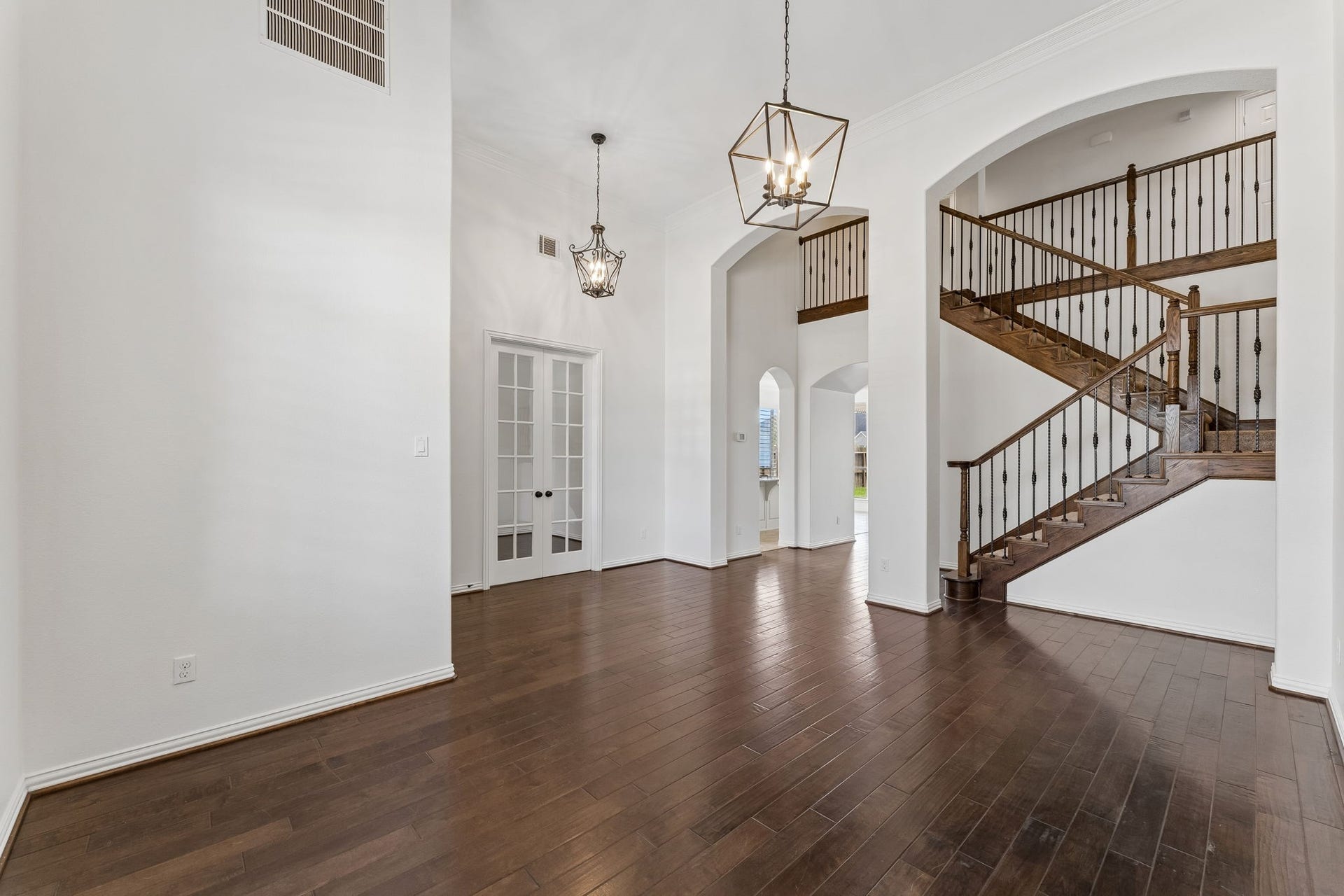 8210 Thunder Ridge Way, Missouri City, TX 77459 Soaring ceilings enhance the spacious living area, complemented by a grand staircase leading to the upstairs den, media room, and additional bedrooms.