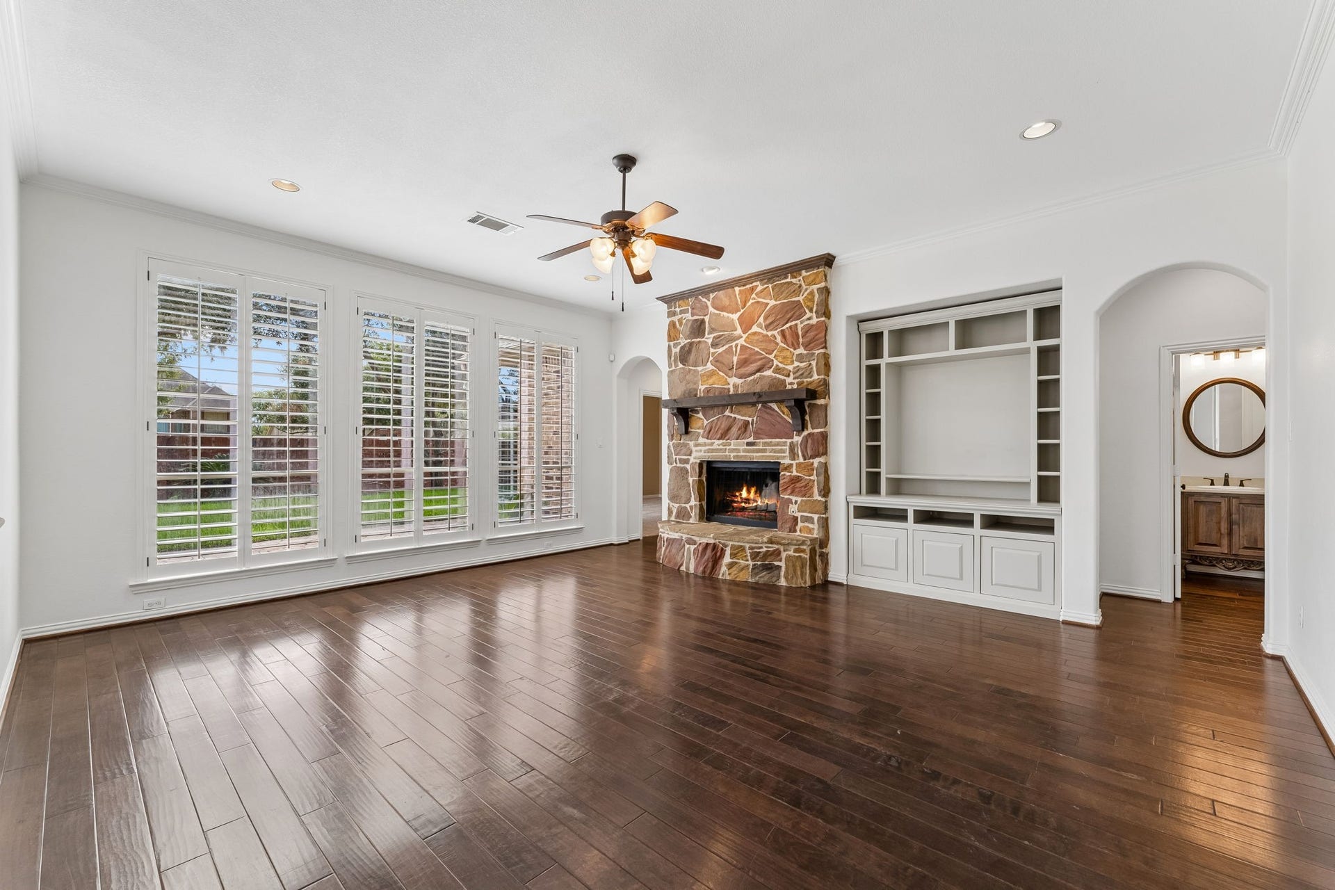 8210 Thunder Ridge Way, Missouri City, TX 77459 Expansive family room with a stunning wall of windows overlooking the backyard, complemented by a convenient powder room nearby.