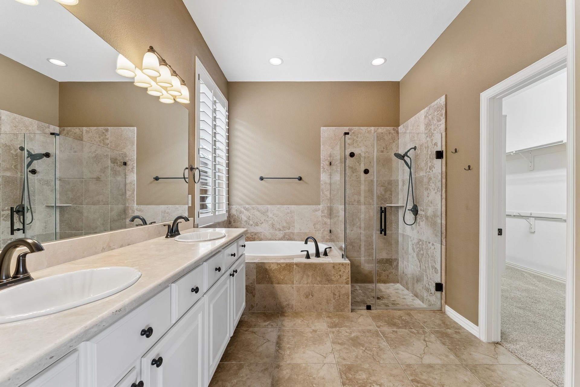 8210 Thunder Ridge Way, Missouri City, TX 77459 Luxurious primary bathroom featuring dual sinks, a sleek glass-enclosed shower, and a relaxing soaking tub, all enhanced by elegant tilework.