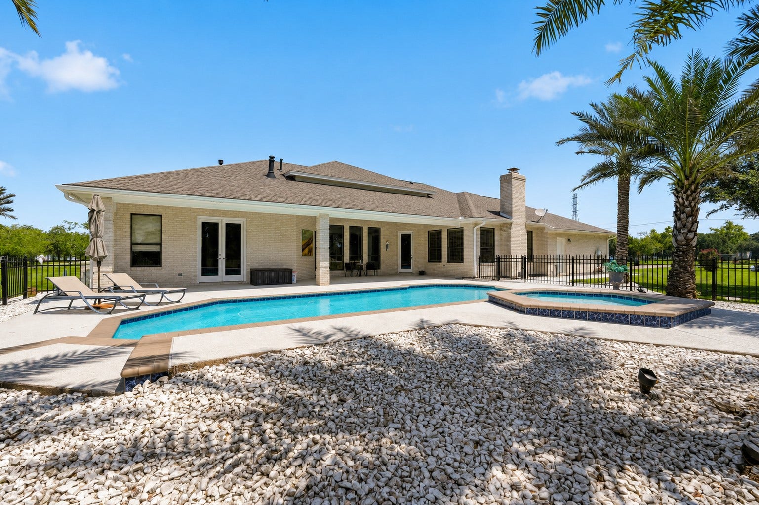 835 Hall Road, Alvin, TX 77511 Rear view of the home, pool, spa and covered patio