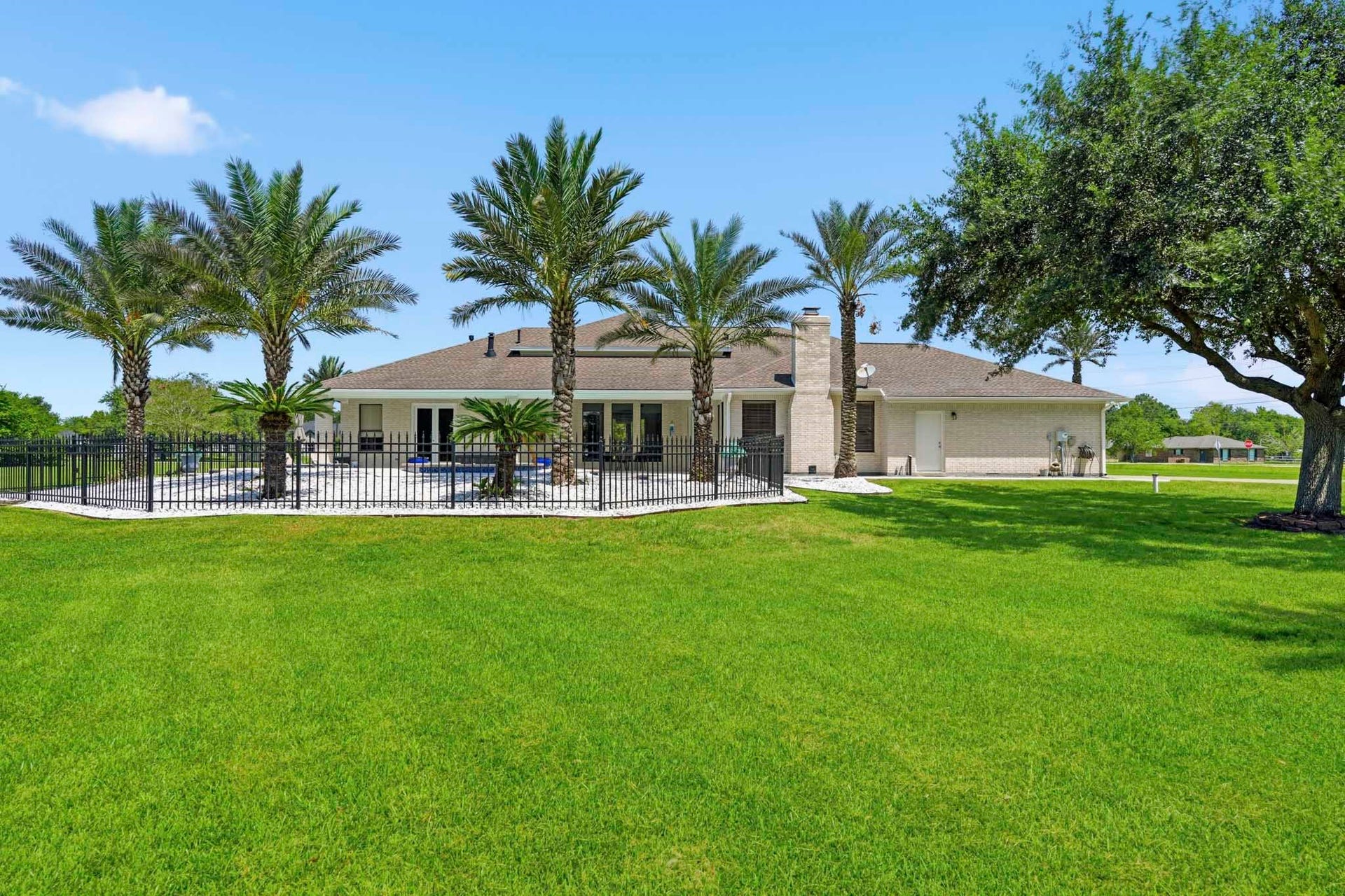 835 Hall Road, Alvin, TX 77511 Rear exterior surrounded by mature trees and tropical landscaping