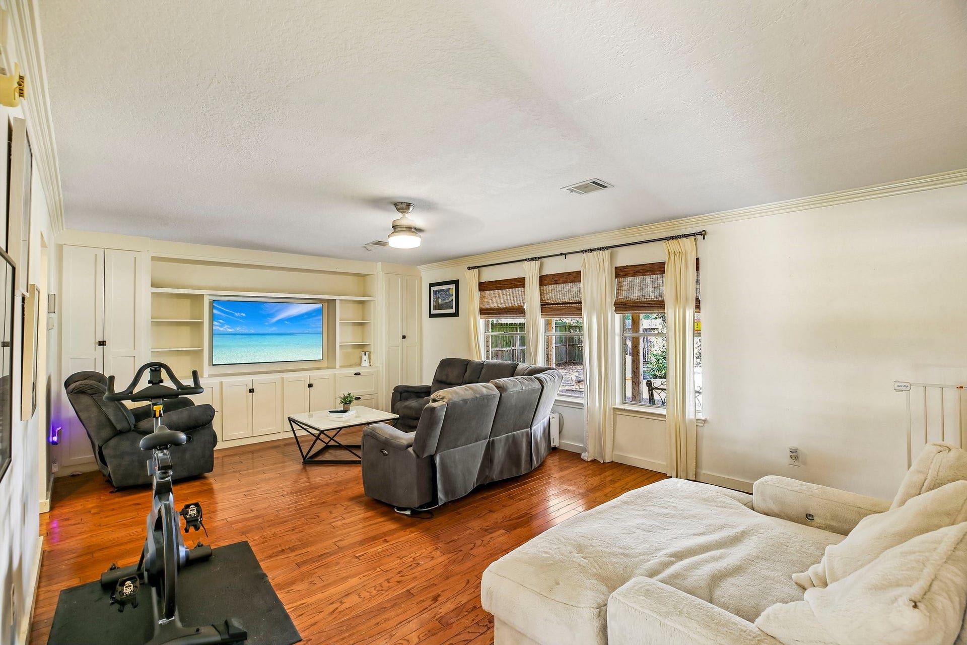 5501 Pecos Street, Dickinson, TX 77539 Living room with a wall of beautiful built-ins and hard wood floors.