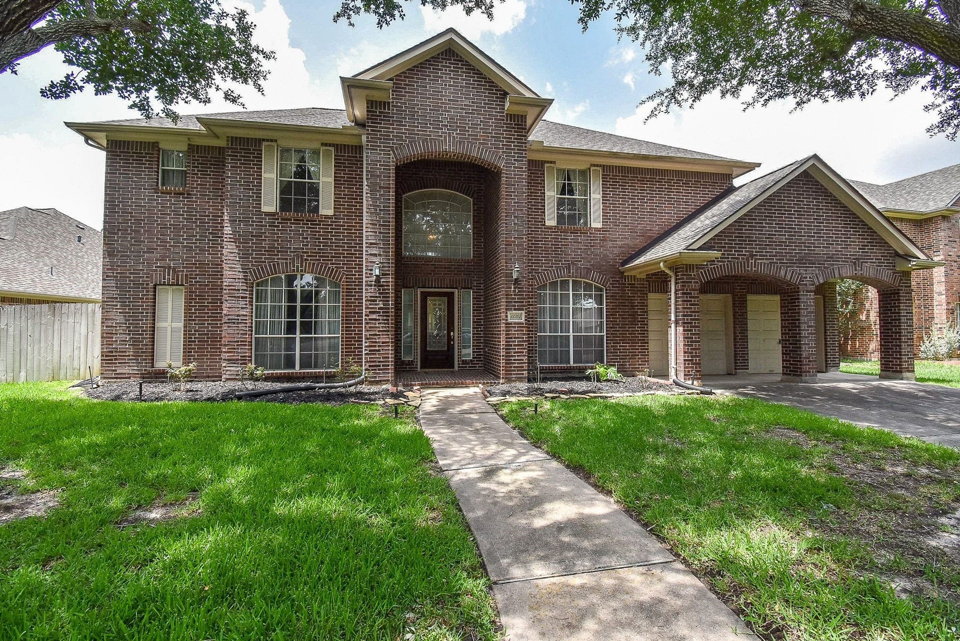 11202 Hundred Bridge Lane, Sugar Land, TX 77498 Welcome to this spacious two-story brick home with large windows, a covered entryway, and an attached two-car garage. The house is set on a well-maintained lawn with mature trees, offering a welcoming and attractive curb appeal.