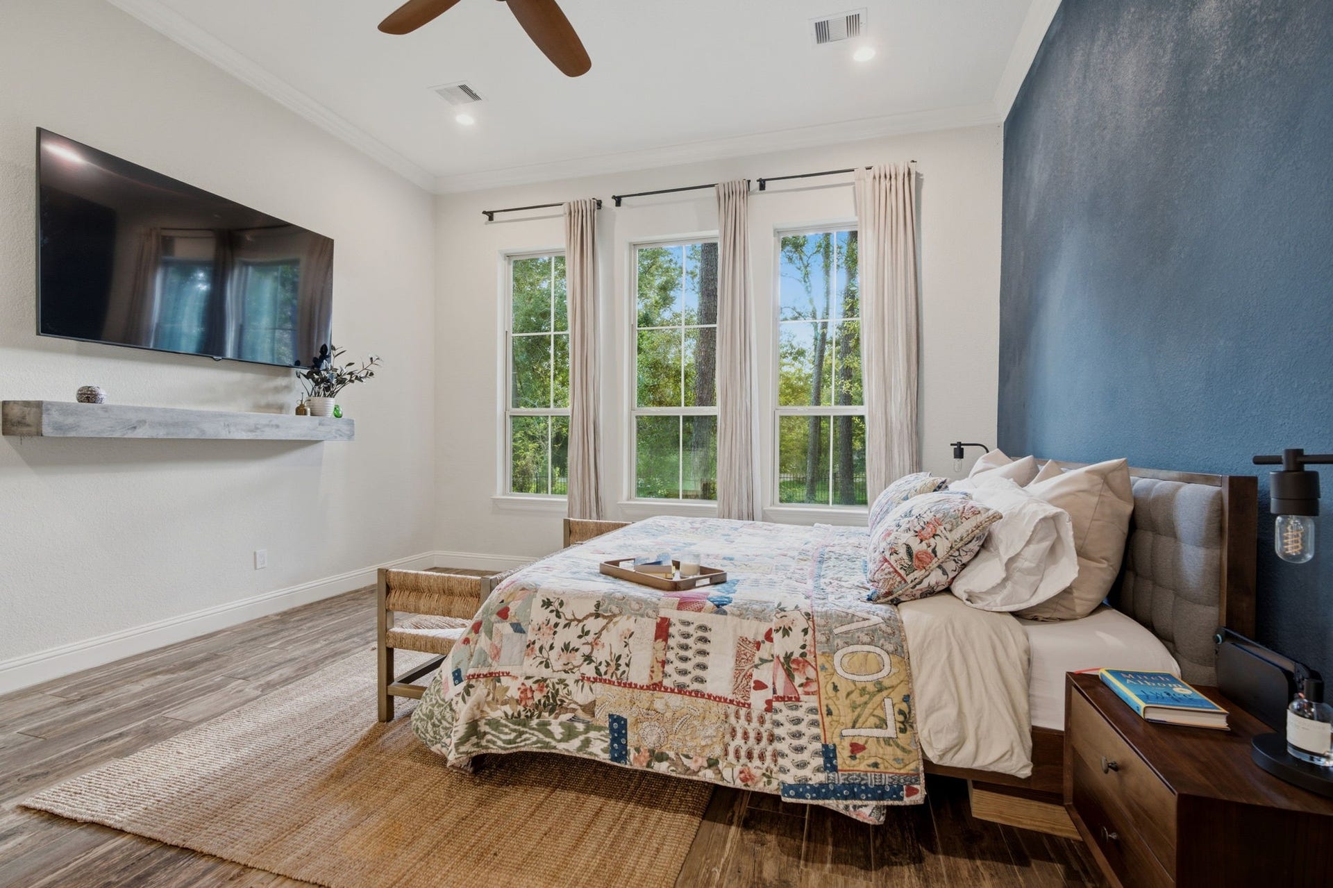 25103 W Tara Plantation Drive, Tomball, TX 77375 Primary bedroom with large windows, and peaceful wooden view.