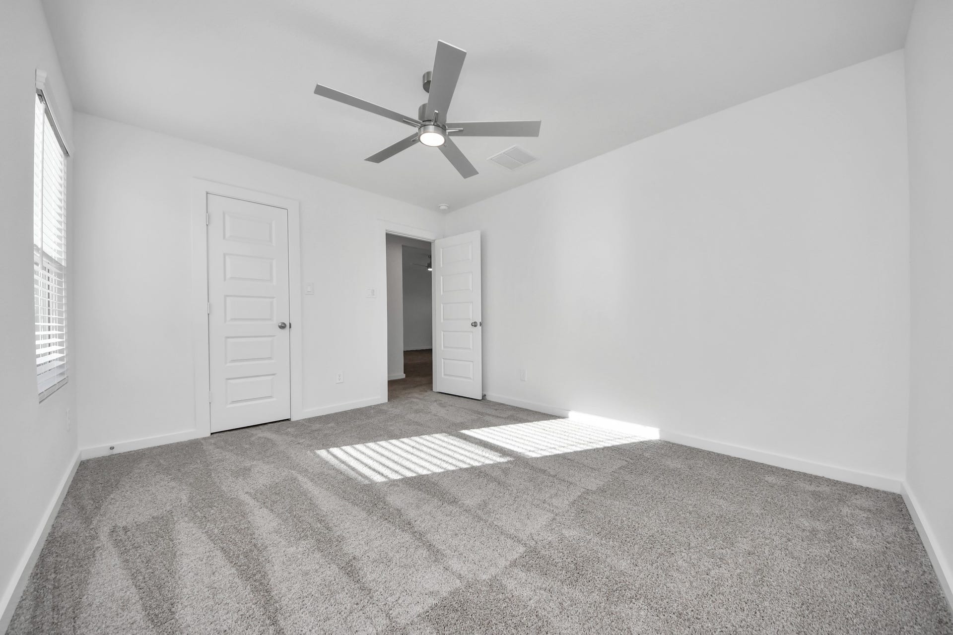 Secondary bedroom features plush carpeting, large windows that let in plenty of natural light, bright paint, and spacious closets. Sample photo of completed home with similar floor plan. Actual colors and selections may vary.
