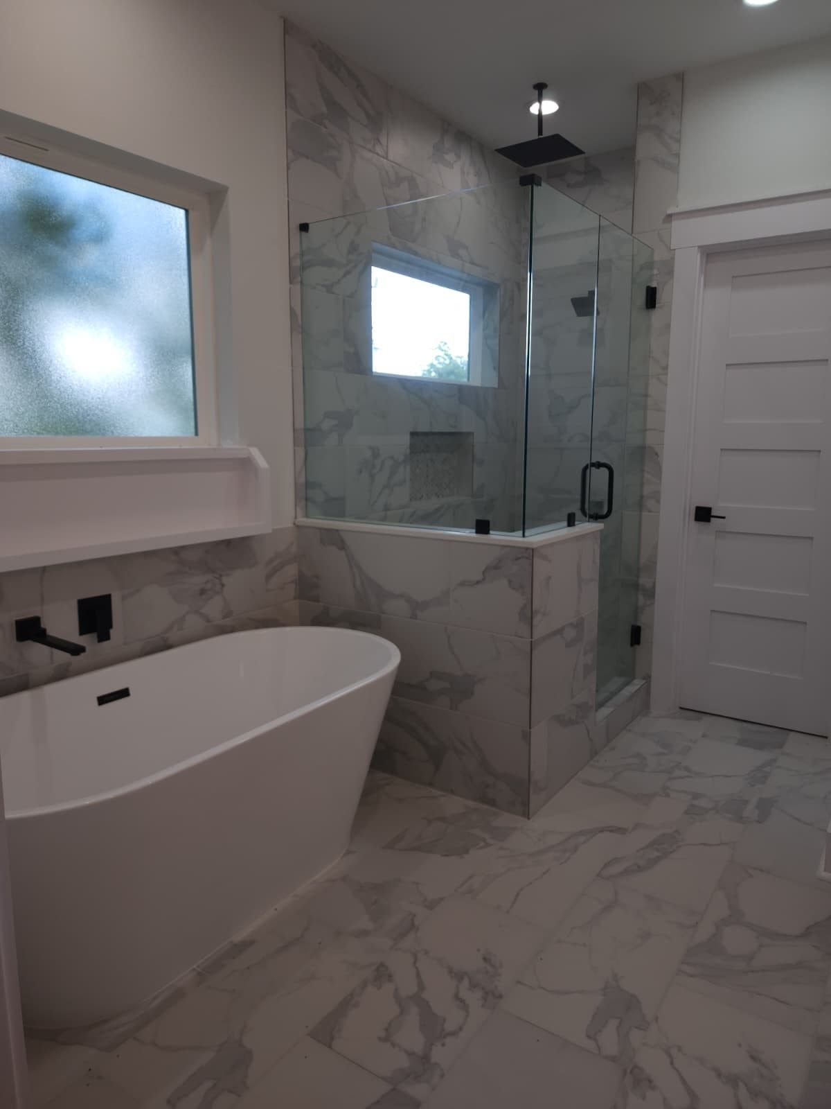 5518E CORTLANDT Street, Houston, TX 77076 Indulge in relaxation with a stand-alone tub featuring a candle shelf, complemented by a separate shower with frameless glass and a soothing rain showerhead.