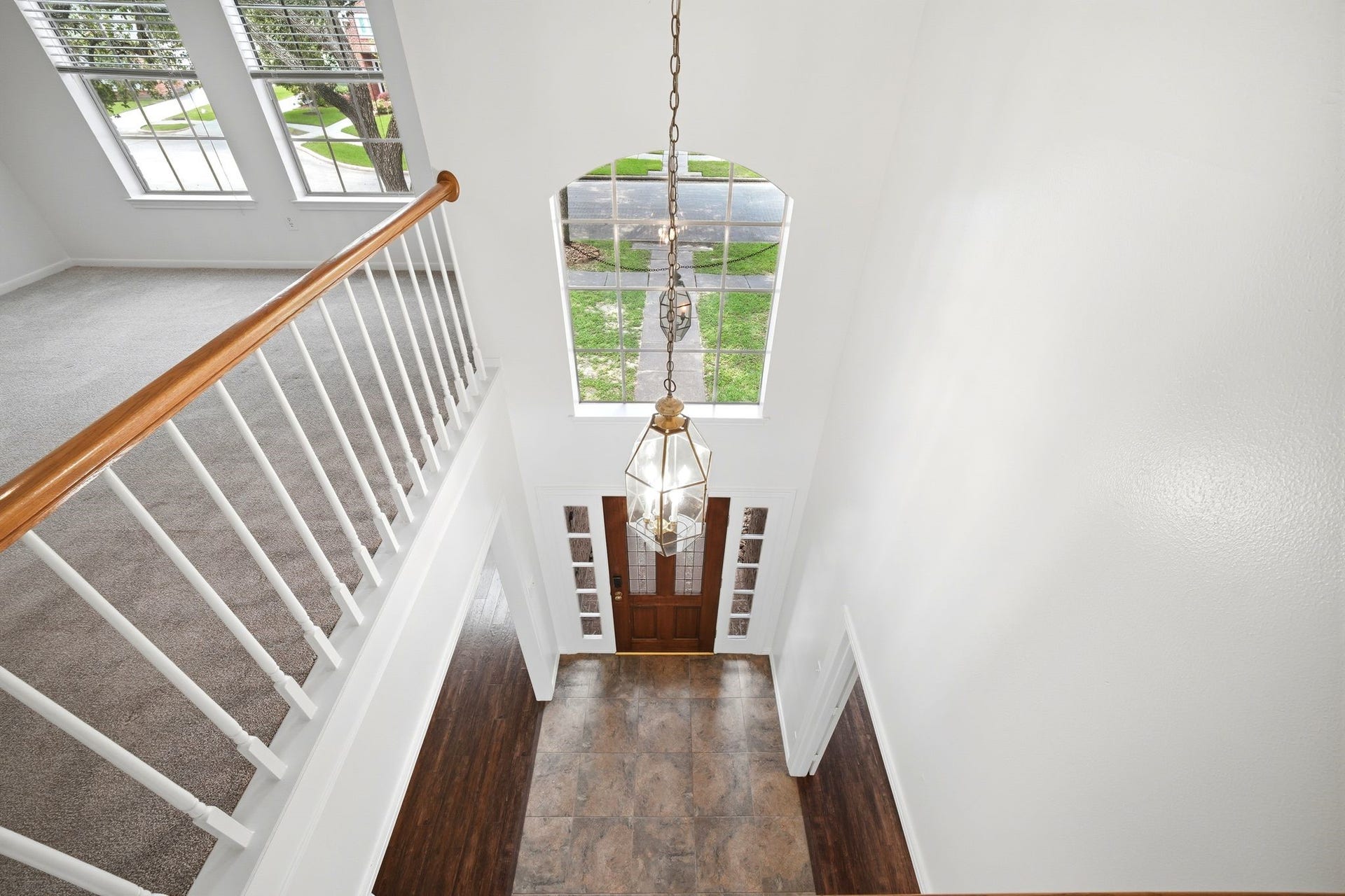 2216 Fairwater Park Drive, League City, TX 77573 Gaze upon the elegant entry hall from above, featuring a grand chandelier and an inviting front door that floods the space with natural light through expansive windows.